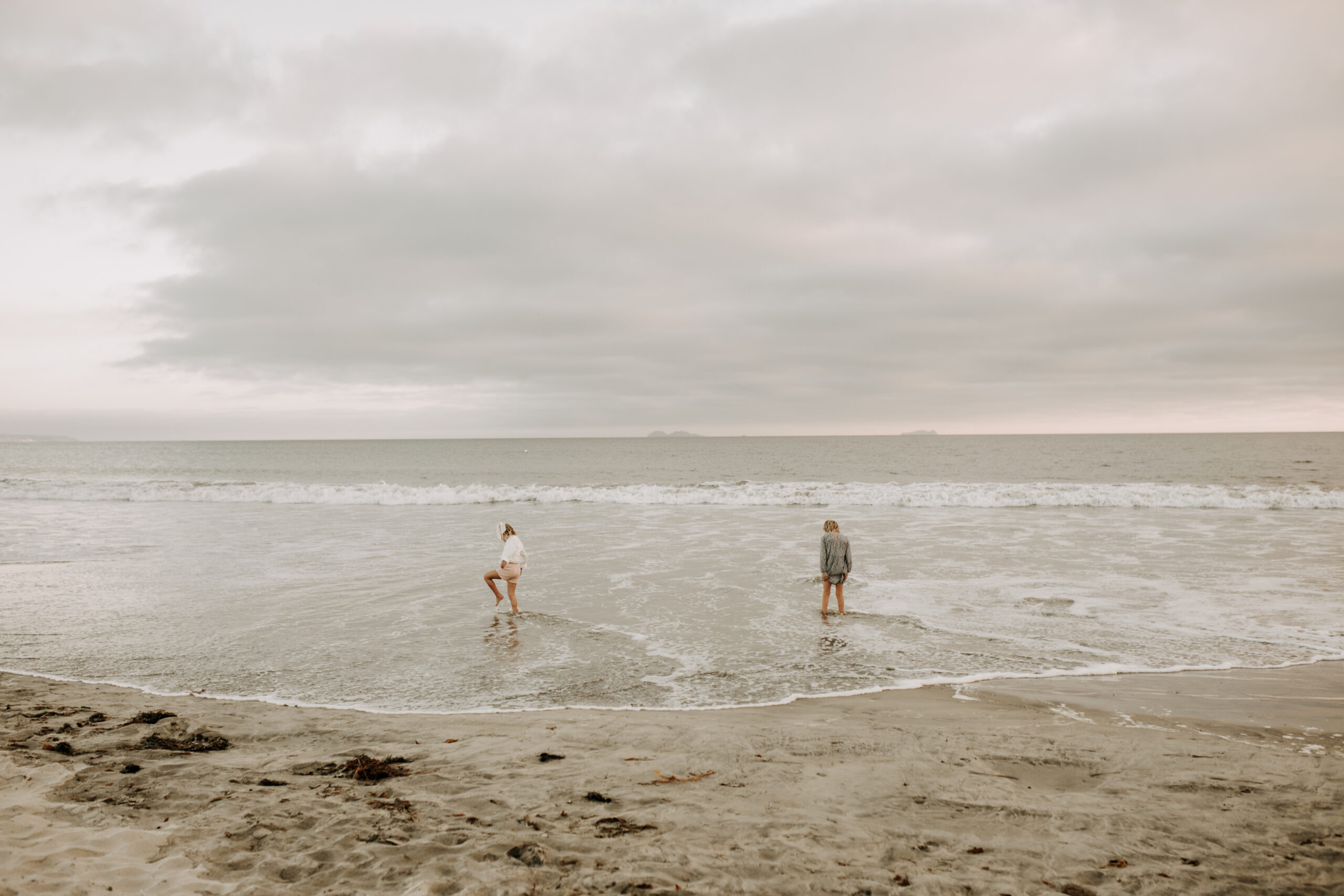 cool toned family photoshoot beach photos family photos on the beach cloudy vibes San Diego family photographer lifestyle photographer beach photoshoot inspo