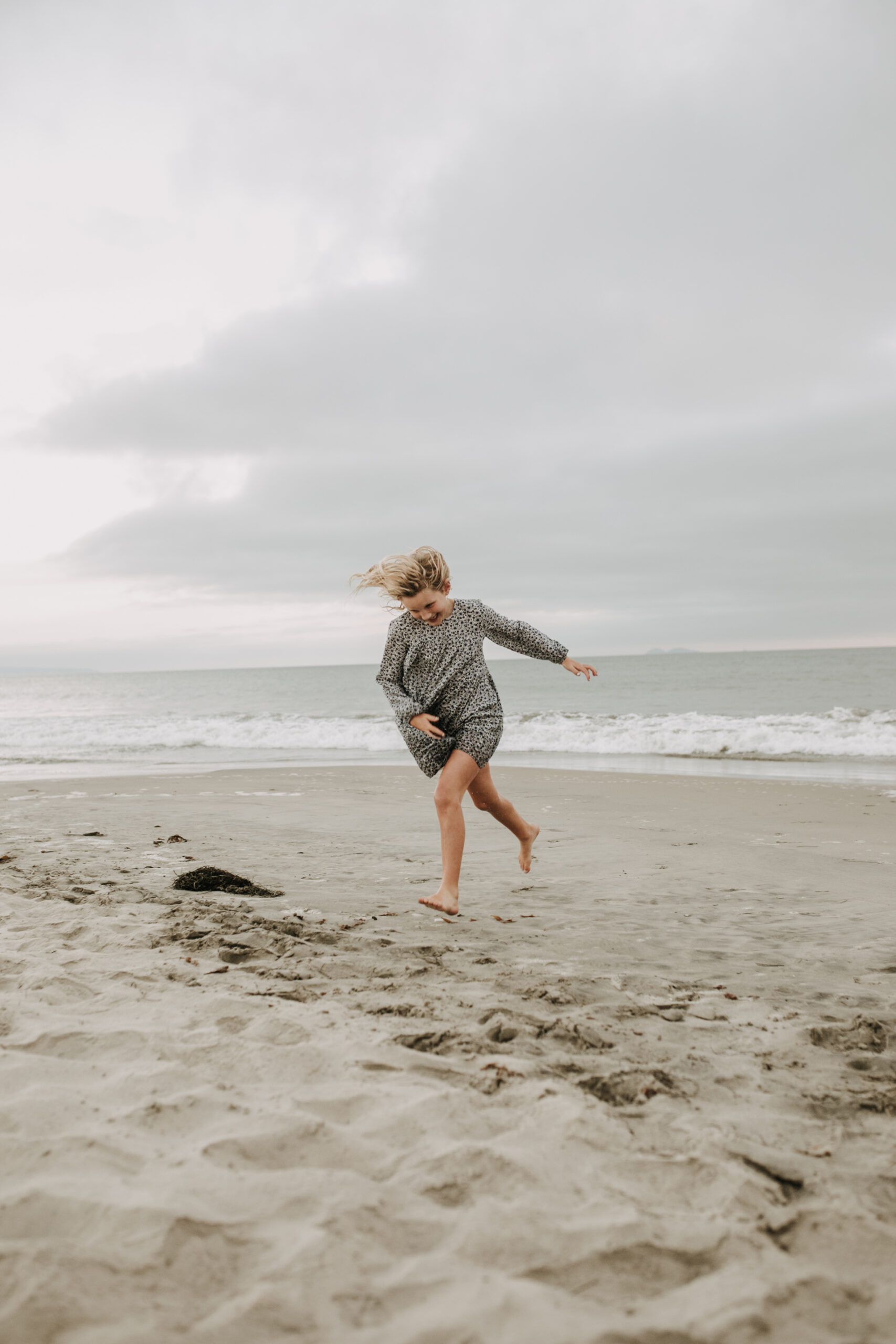 cool toned family photoshoot beach photos family photos on the beach cloudy vibes San Diego family photographer lifestyle photographer beach photoshoot inspo