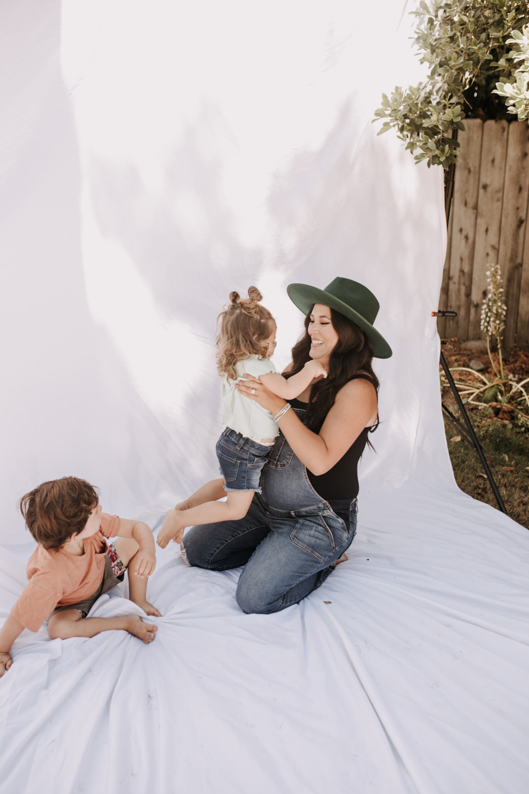 backyard mini session family photos white backdrop outdoor motherhood maternity san diego family photographer