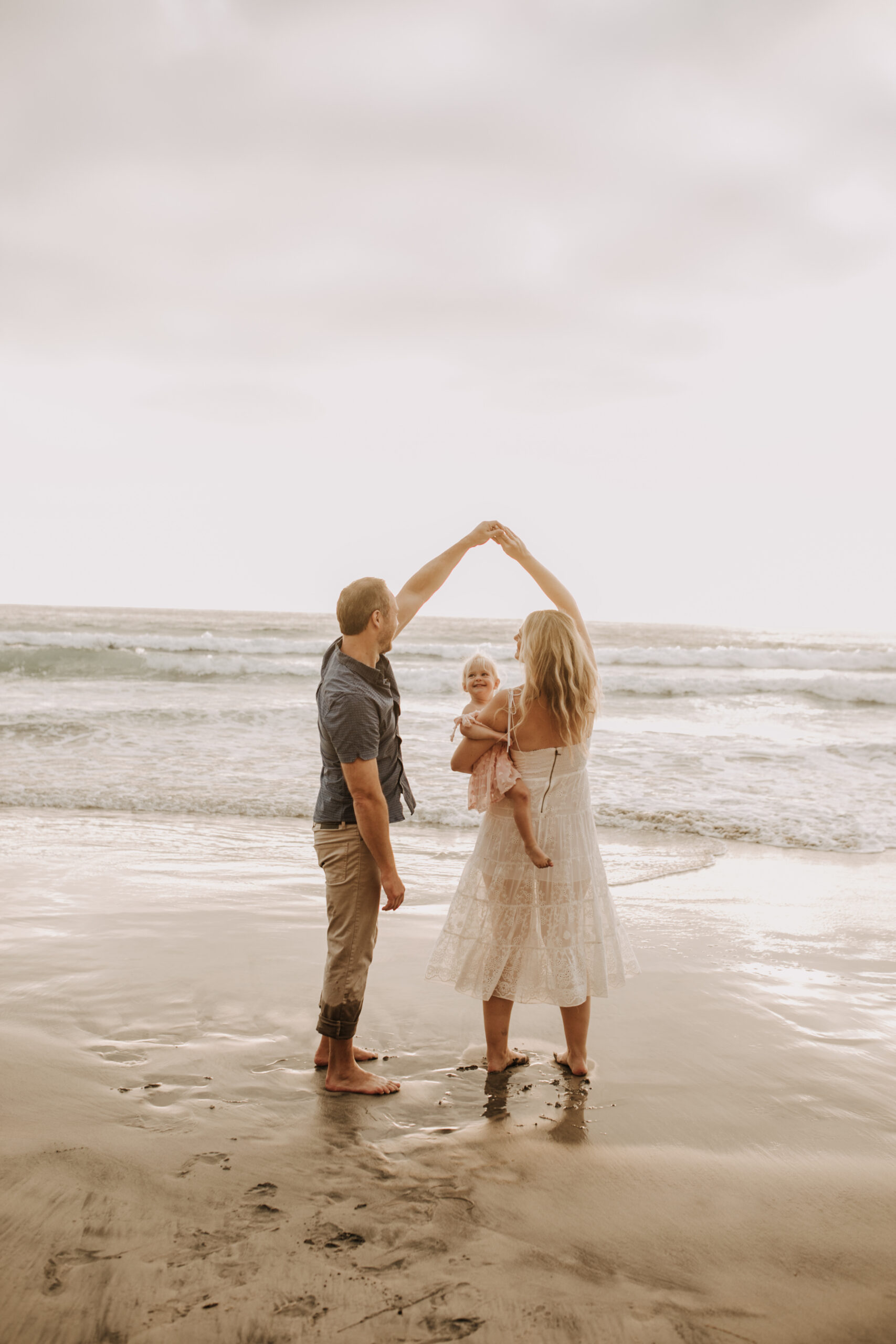 family photos on the beach sunset beach family dad mom baby water golden hour San Diego beach family photos San Diego family photographer