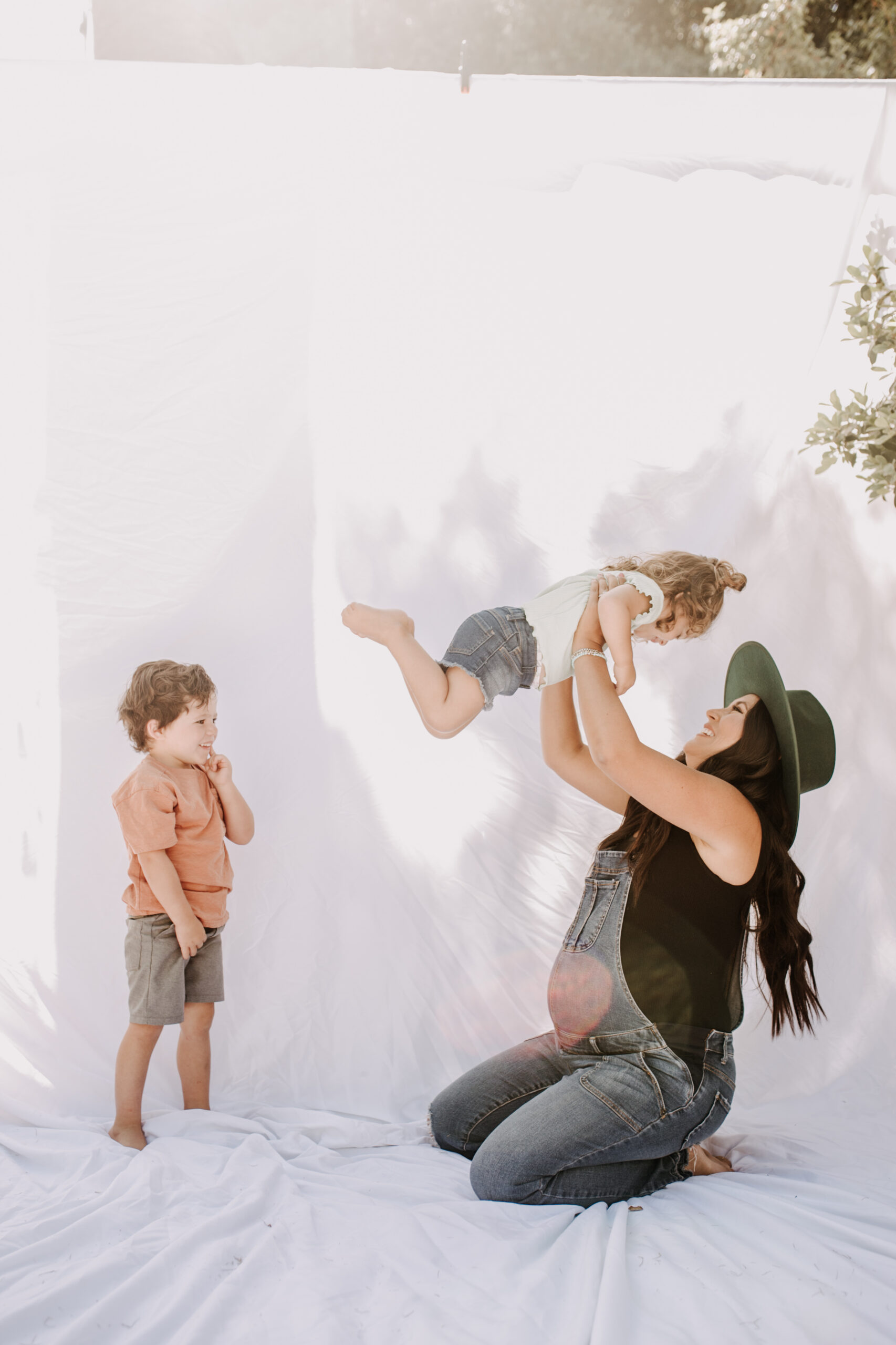 backyard mini session family photos white backdrop outdoor motherhood maternity san diego family photographer