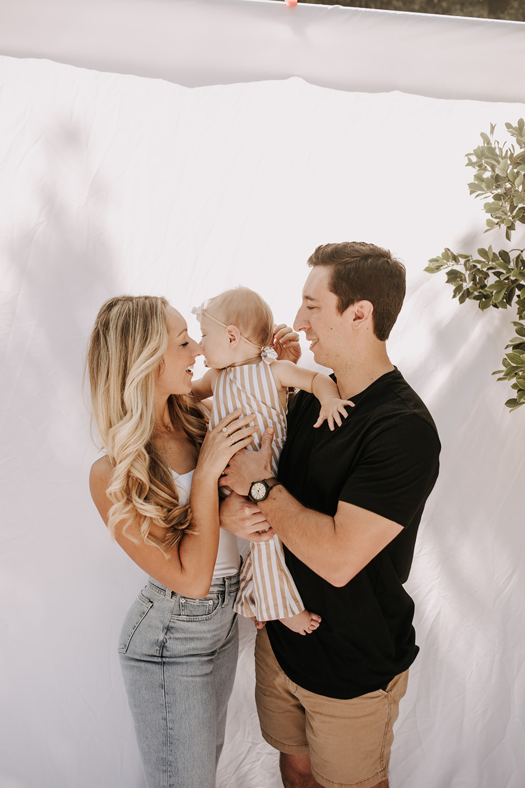 outdoor family photos San Diego family photographer candid family photos mom and dad and baby backyard mini session white backdrop photography