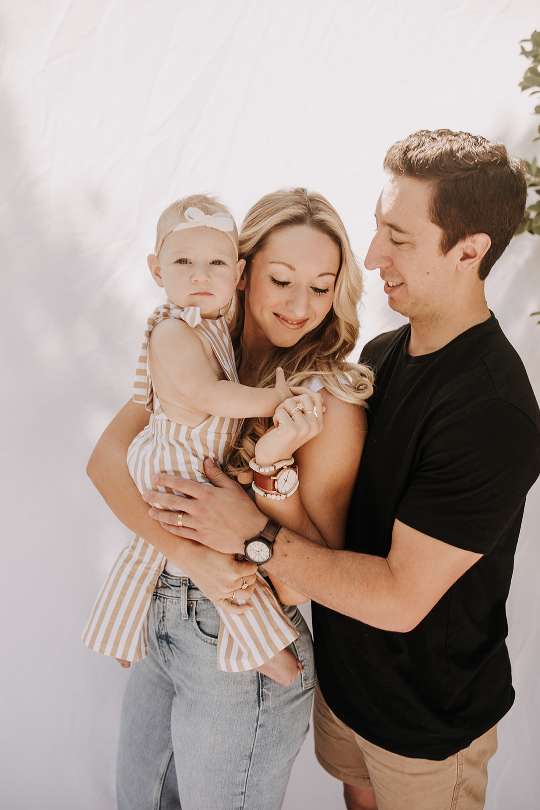 outdoor family photos San Diego family photographer candid family photos mom and dad and baby backyard mini session white backdrop photography