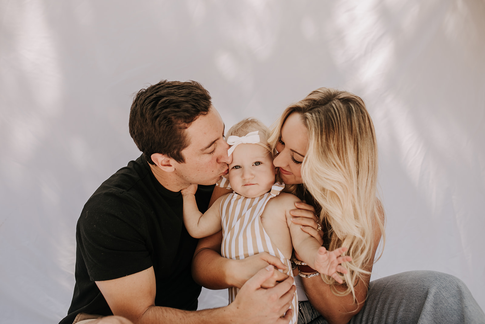 outdoor family photos San Diego family photographer candid family photos mom and dad and baby backyard mini session white backdrop photography