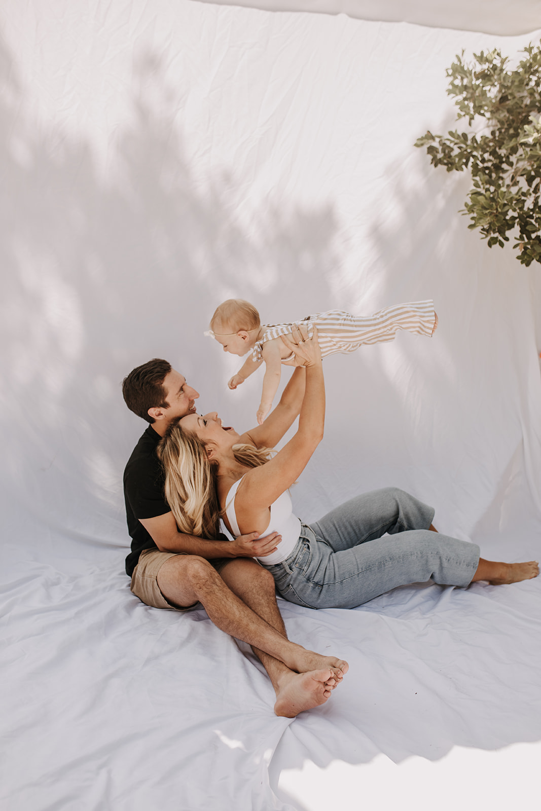 outdoor family photos San Diego family photographer candid family photos mom and dad and baby backyard mini session white backdrop photography