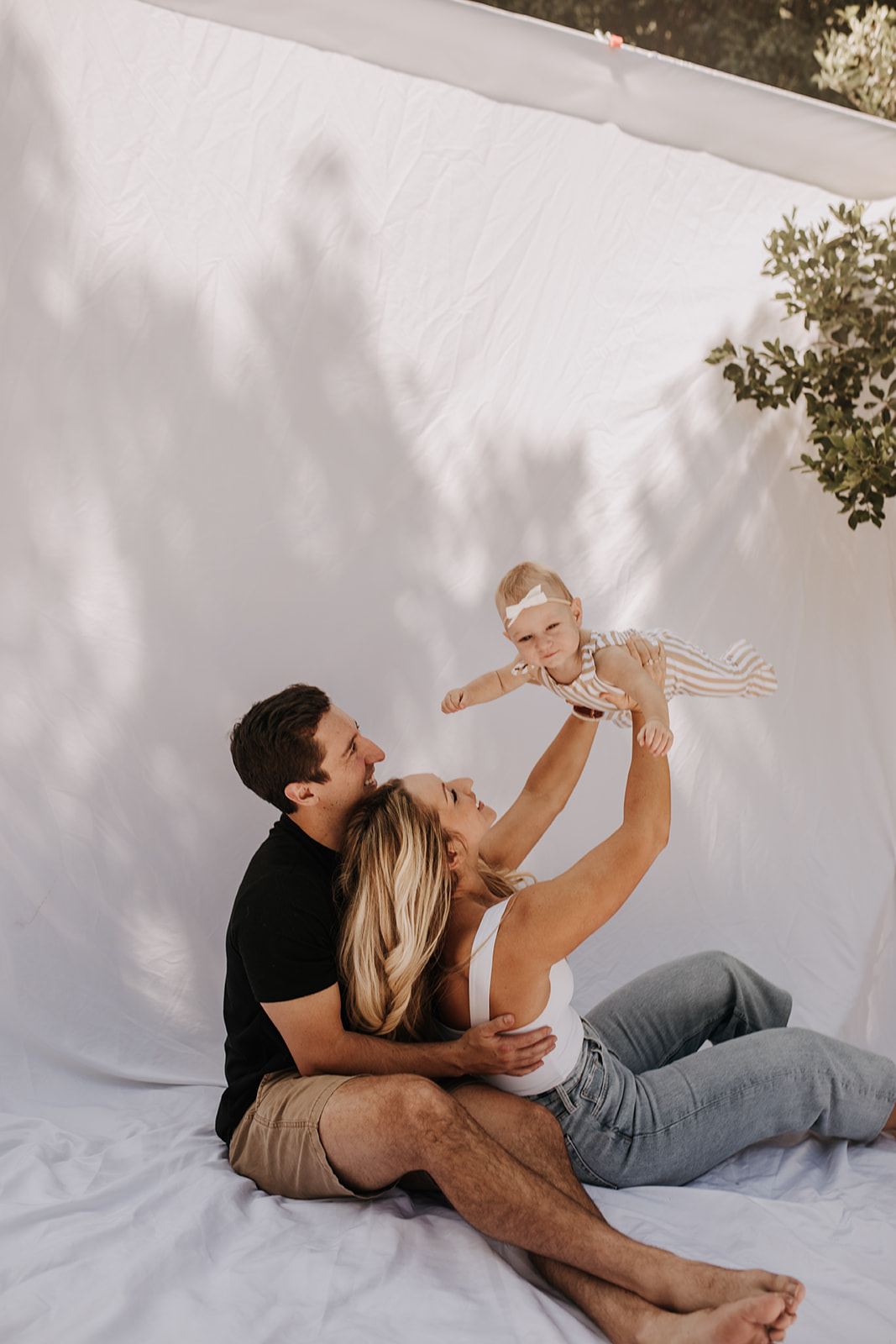 outdoor family photos San Diego family photographer candid family photos mom and dad and baby backyard mini session white backdrop photography