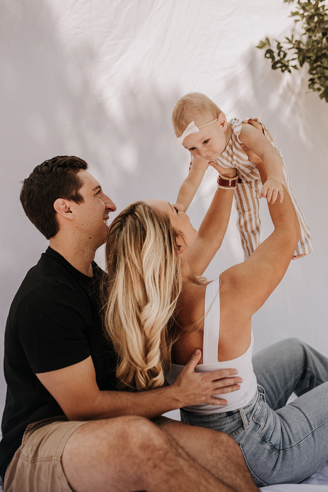 outdoor family photos San Diego family photographer candid family photos mom and dad and baby backyard mini session white backdrop photography