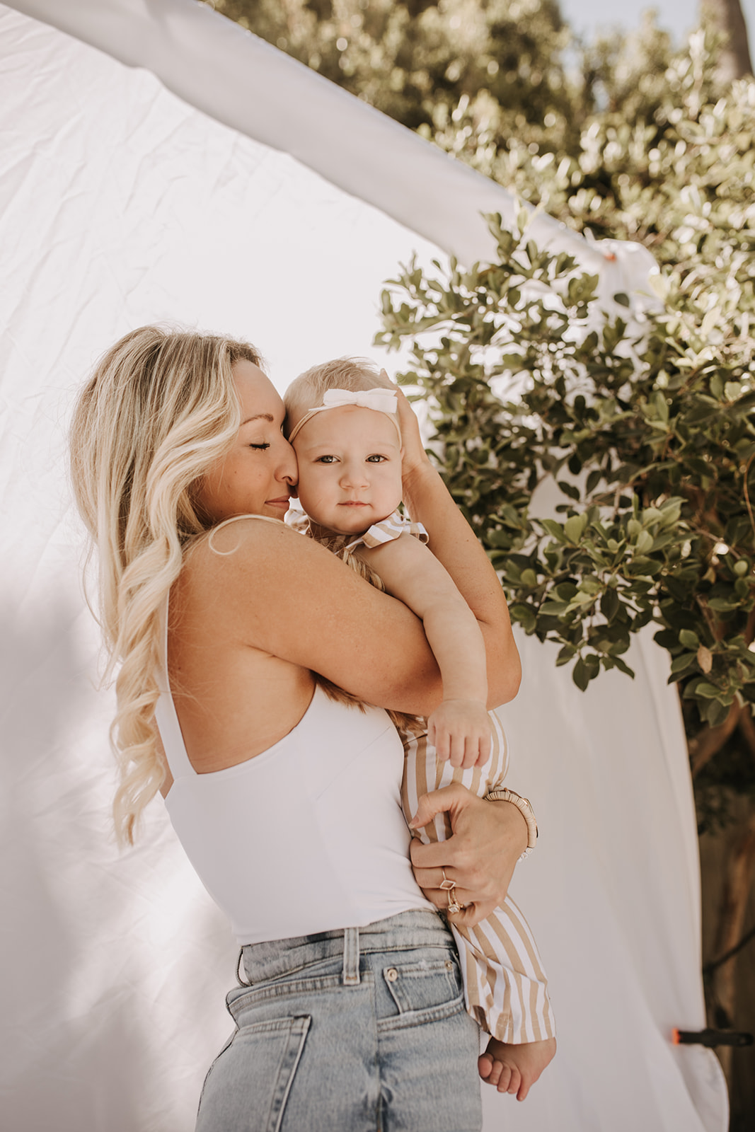 outdoor family photos San Diego family photographer candid family photos mom and dad and baby backyard mini session white backdrop photography