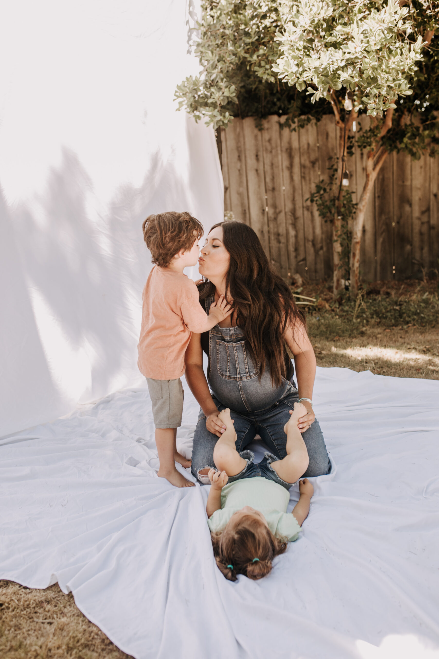 backyard mini session family photos white backdrop outdoor motherhood maternity san diego family photographer