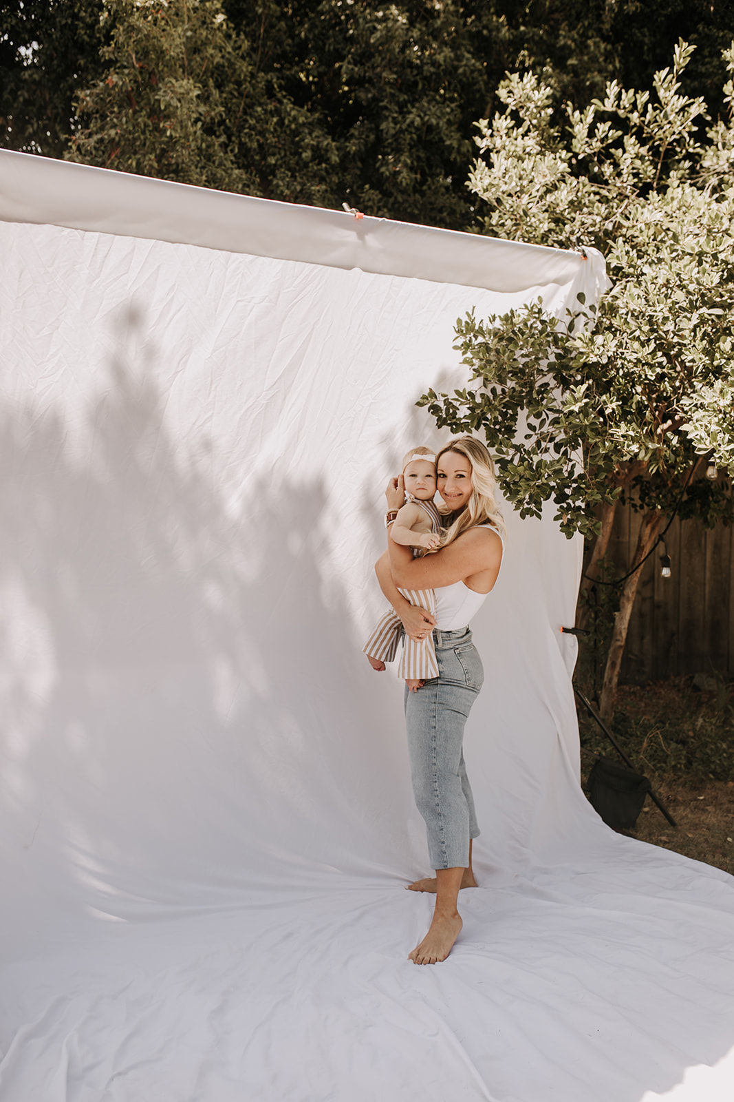 outdoor family photos San Diego family photographer candid family photos mom and dad and baby backyard mini session white backdrop photography