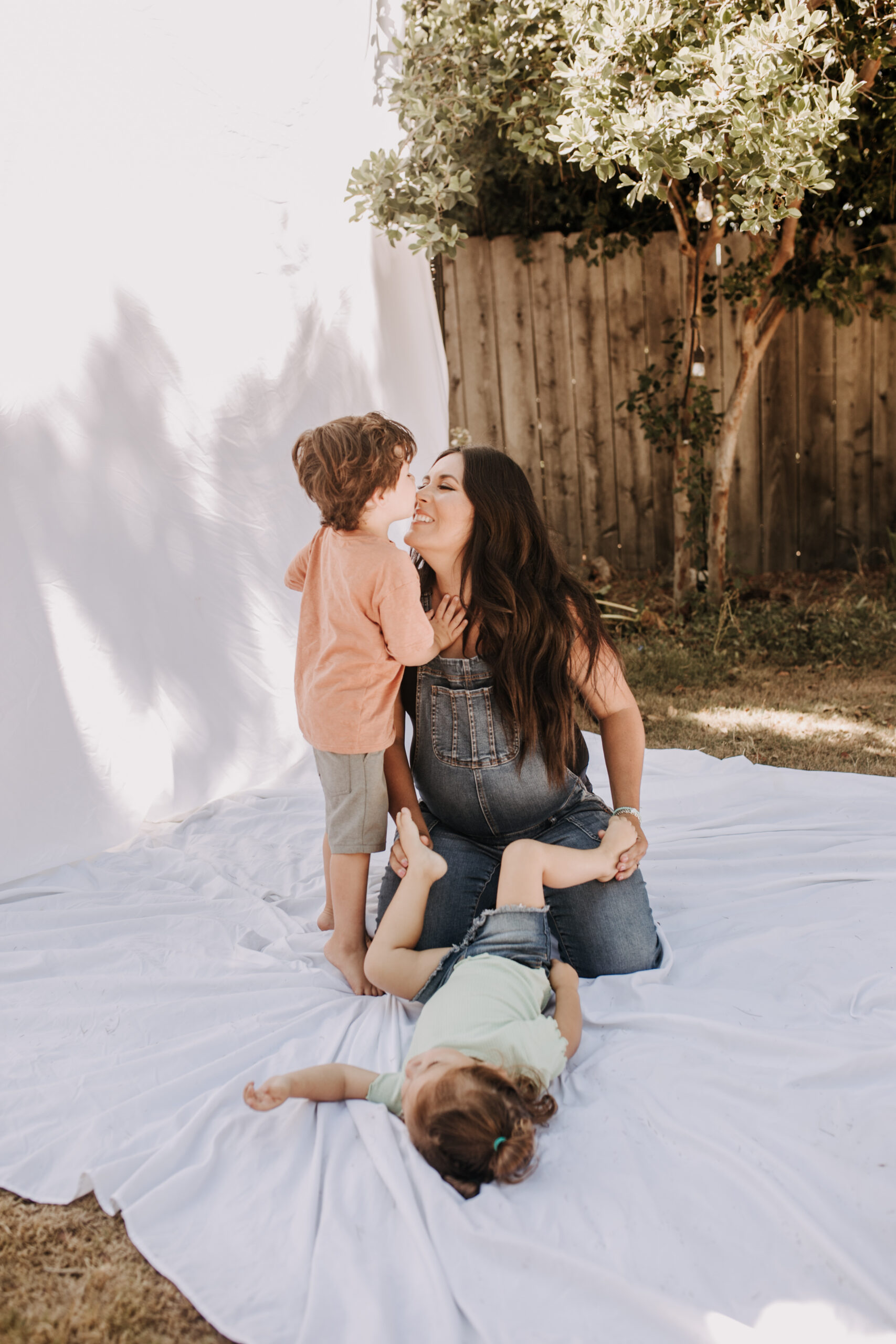 backyard mini session family photos white backdrop outdoor motherhood maternity san diego family photographer