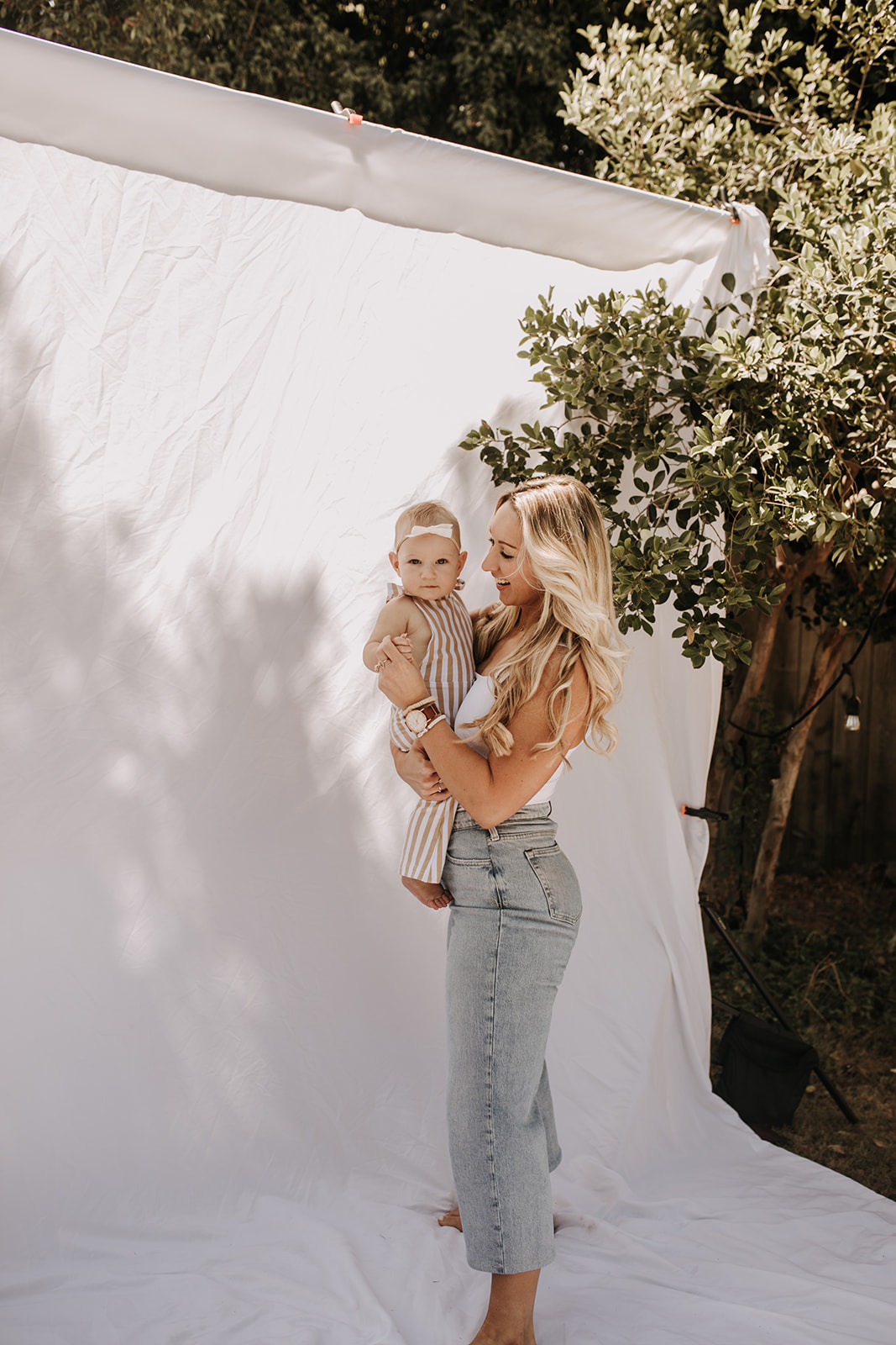 outdoor family photos San Diego family photographer candid family photos mom and dad and baby backyard mini session white backdrop photography