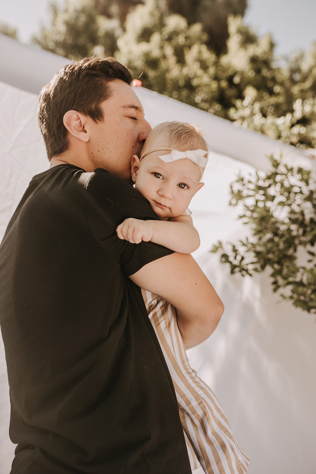 outdoor family photos San Diego family photographer candid family photos mom and dad and baby backyard mini session white backdrop photography