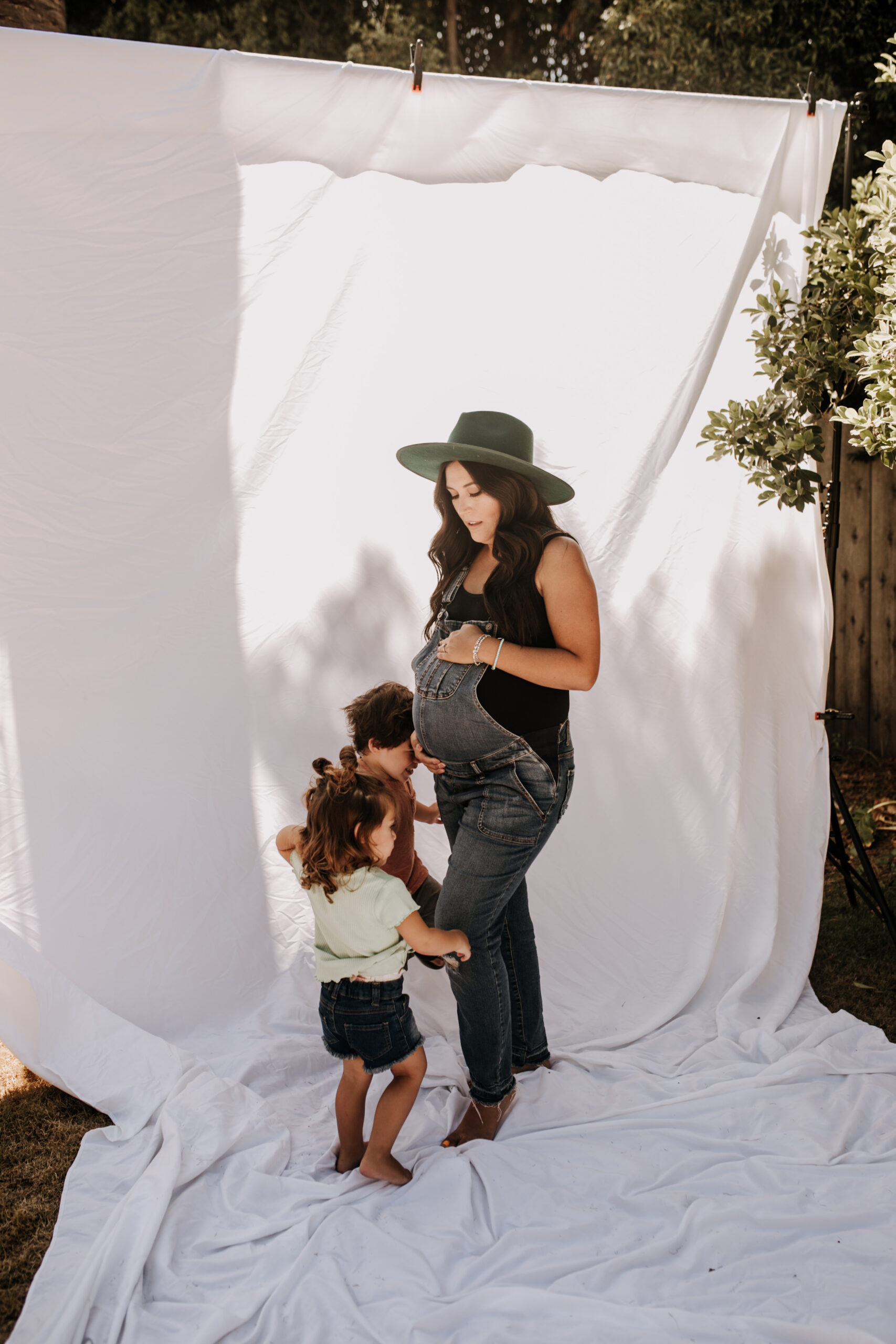 backyard mini session family photos white backdrop outdoor motherhood maternity san diego family photographer