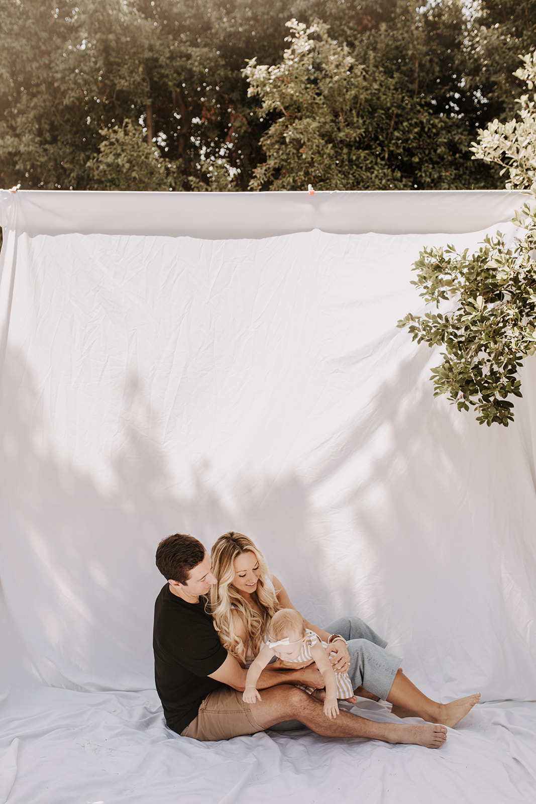 outdoor family photos San Diego family photographer candid family photos mom and dad and baby backyard mini session white backdrop photography