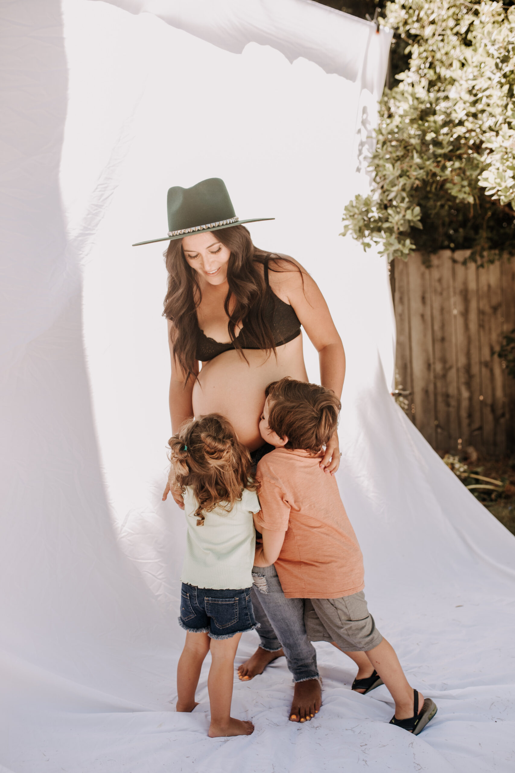 backyard mini session family photos white backdrop outdoor motherhood maternity san diego family photographer