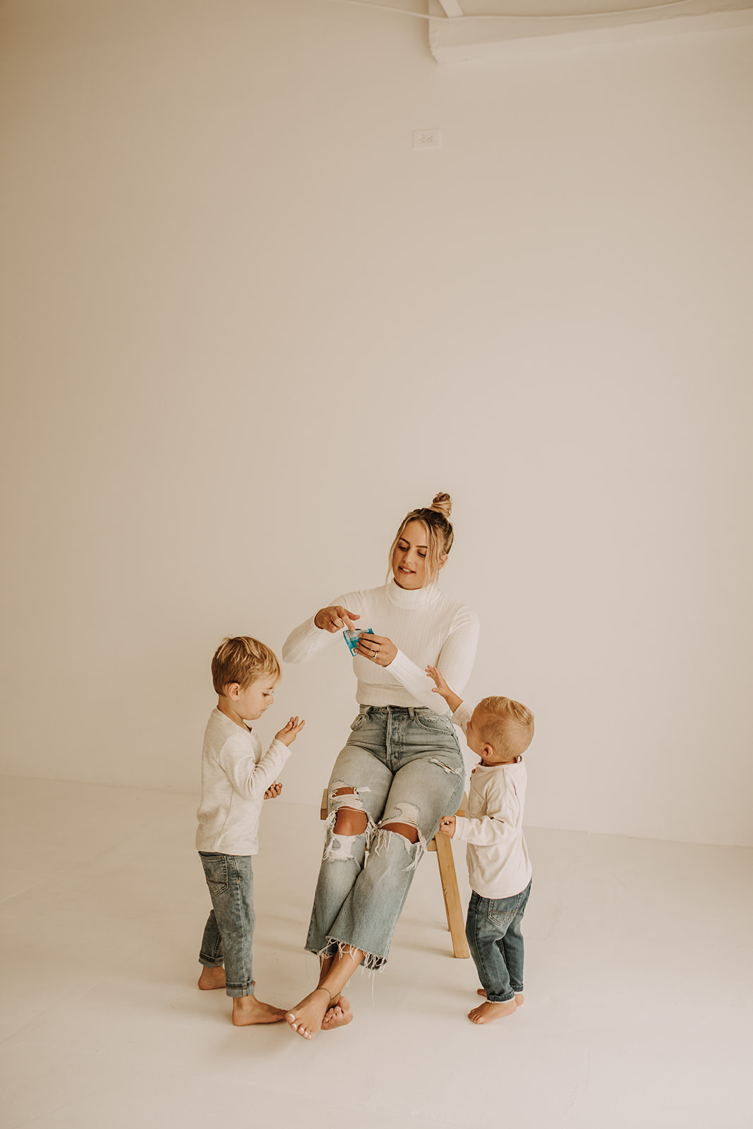 studio mini session indoor mini photoshoot white backdrop lain and simple family photos maternity photos bright and warm toned neutral motherhood photos San Diego family photographer Sabrina kinsella sabrinalynnphoto