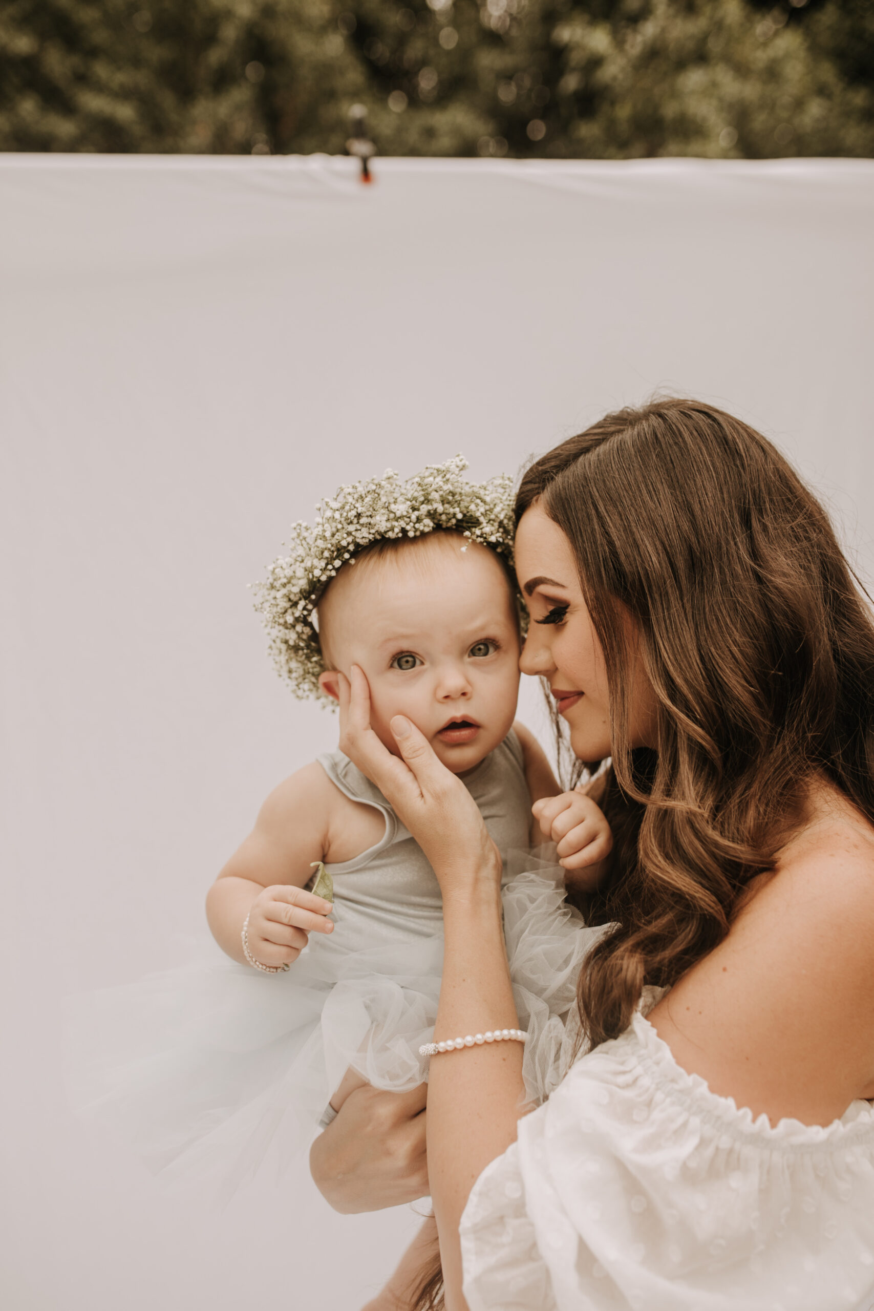 springtime soft light daisies mama and me mom and baby white dress white backdrop flower crown motherhood photos motherhood photography San Diego maternity photographer family photographer Sabrina kinsella outdoor photos green trees backyard mini session