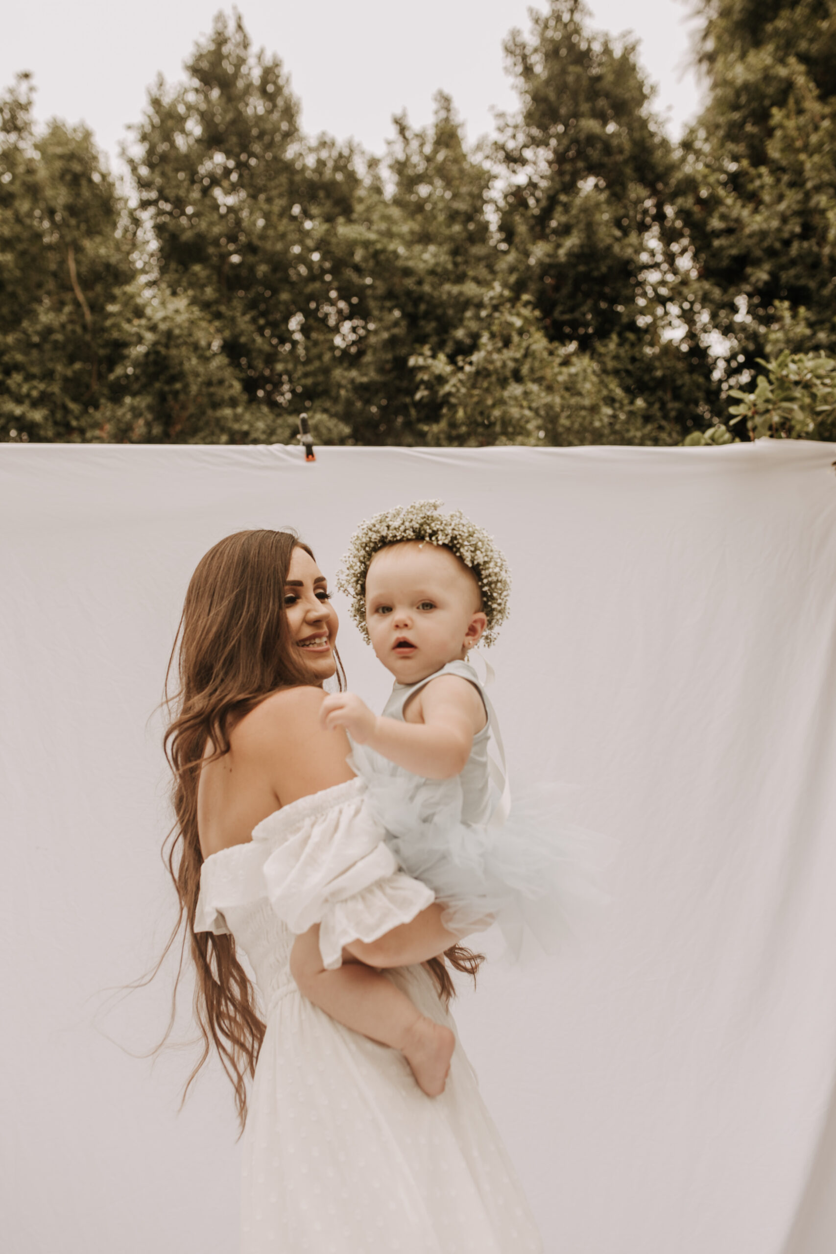 springtime soft light daisies mama and me mom and baby white dress white backdrop flower crown motherhood photos motherhood photography San Diego maternity photographer family photographer Sabrina kinsella outdoor photos green trees backyard mini session