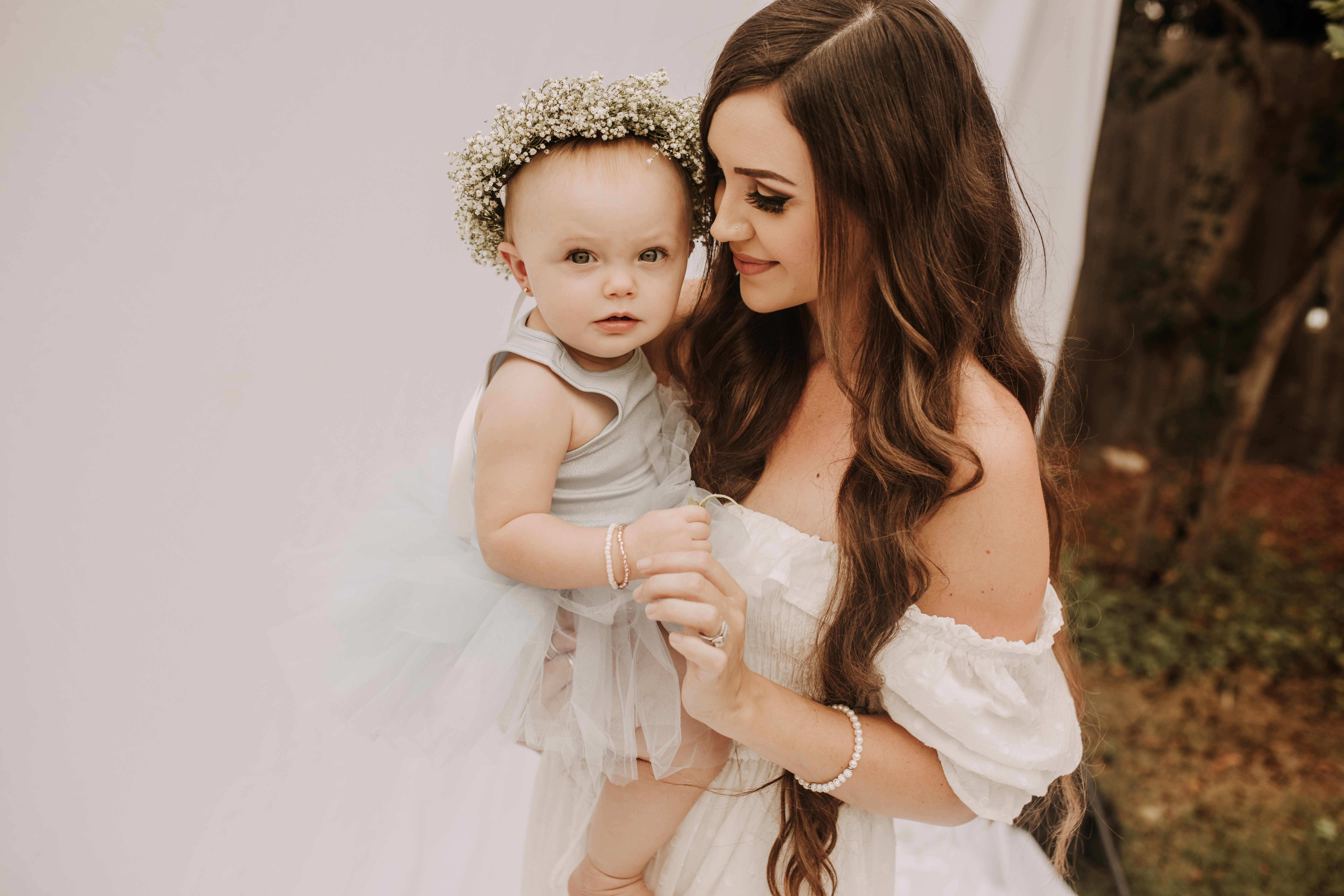 springtime soft light daisies mama and me mom and baby white dress white backdrop flower crown motherhood photos motherhood photography San Diego maternity photographer family photographer Sabrina kinsella outdoor photos green trees backyard mini session