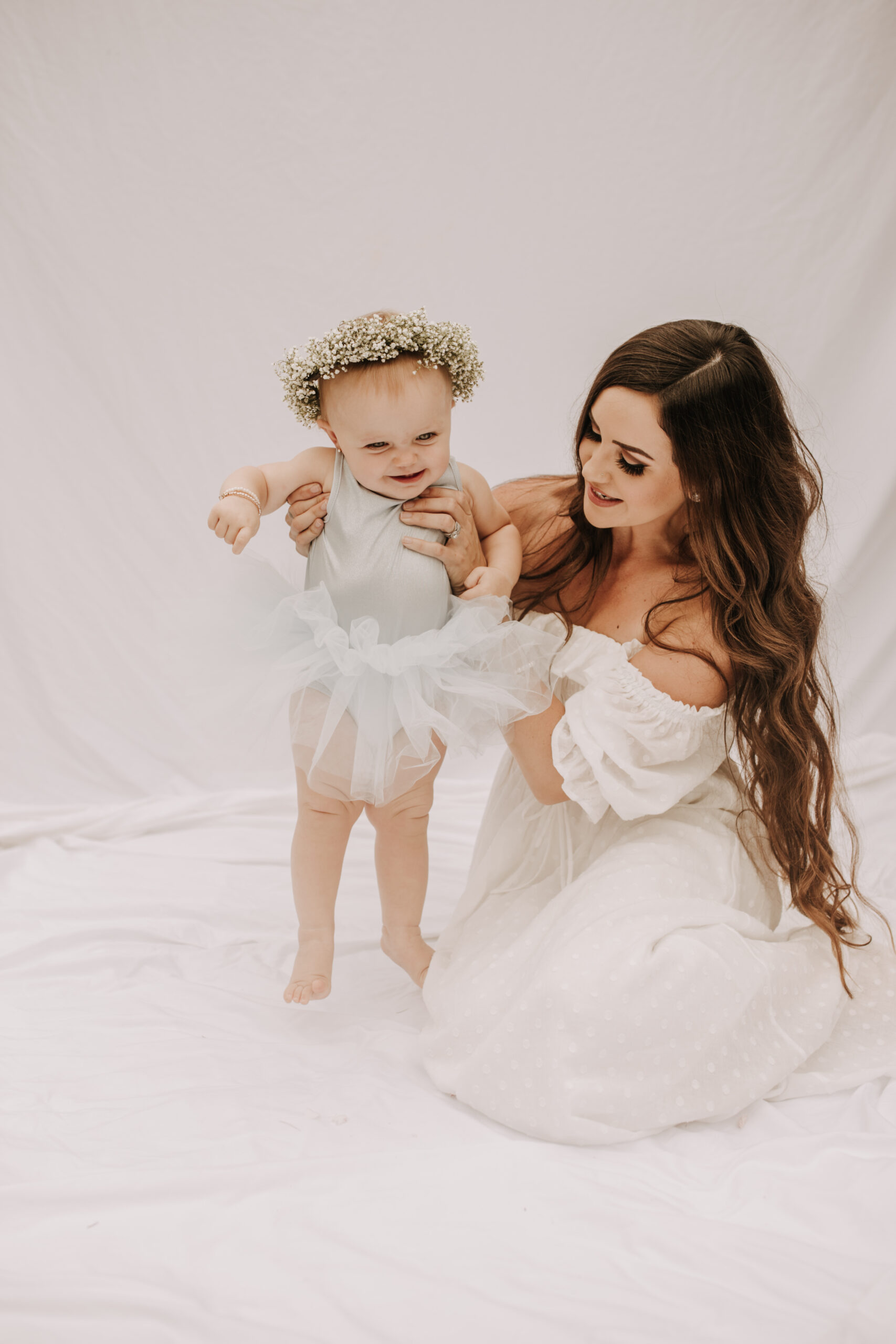 springtime soft light daisies mama and me mom and baby white dress white backdrop flower crown motherhood photos motherhood photography San Diego maternity photographer family photographer Sabrina kinsella outdoor photos green trees backyard mini session