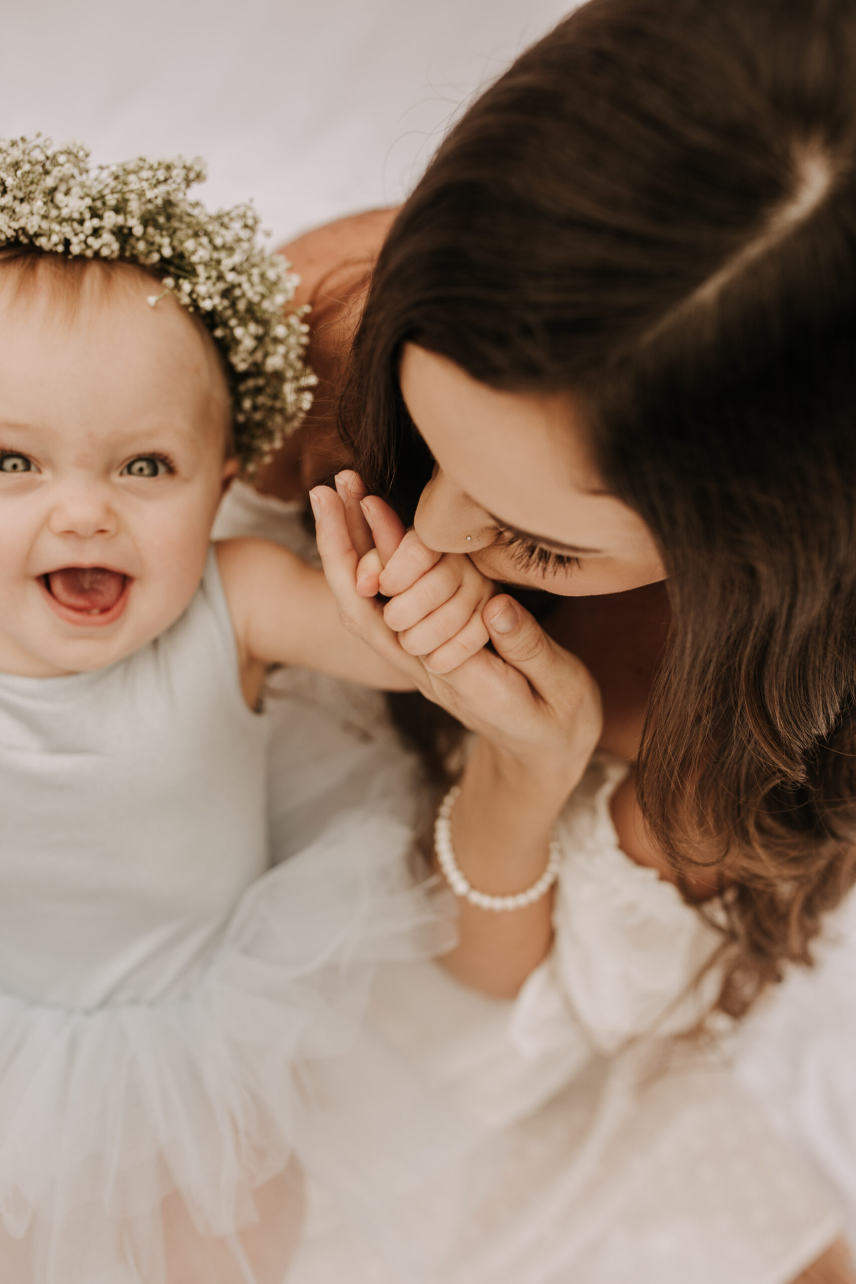 springtime soft light daisies mama and me mom and baby white dress white backdrop flower crown motherhood photos motherhood photography San Diego maternity photographer family photographer Sabrina kinsella outdoor photos green trees backyard mini session