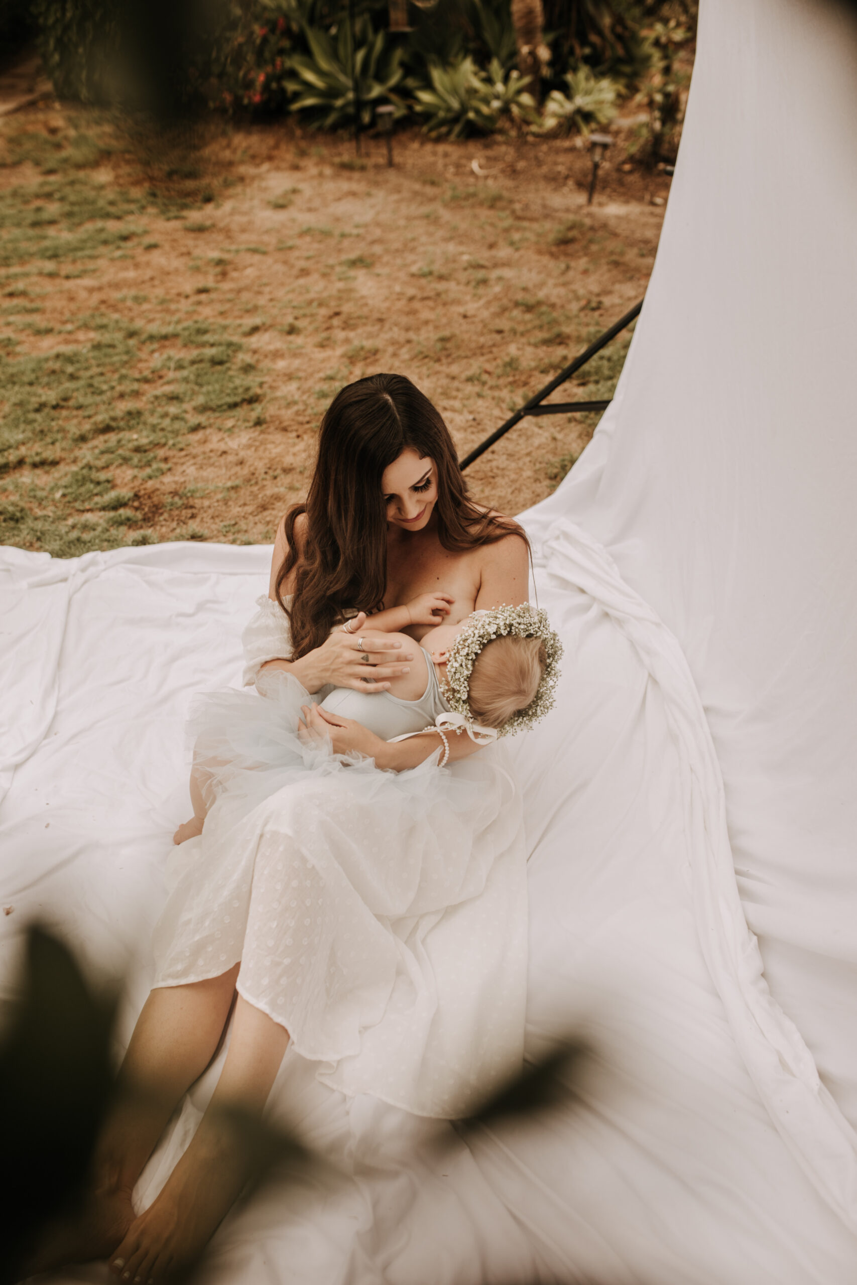 springtime soft light daisies mama and me mom and baby white dress white backdrop flower crown motherhood photos motherhood photography San Diego maternity photographer family photographer Sabrina kinsella outdoor photos green trees backyard mini session