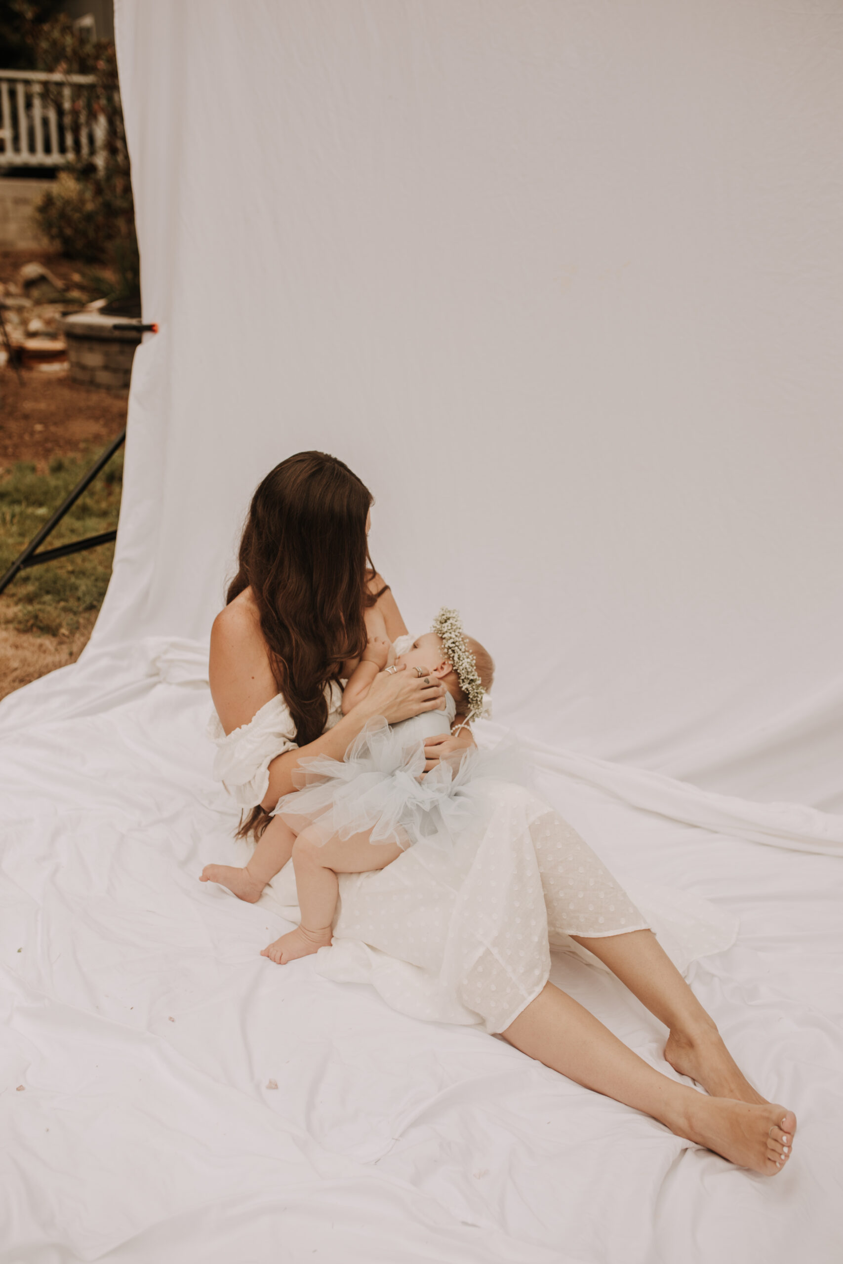 springtime soft light daisies mama and me mom and baby white dress white backdrop flower crown motherhood photos motherhood photography San Diego maternity photographer family photographer Sabrina kinsella outdoor photos green trees backyard mini session