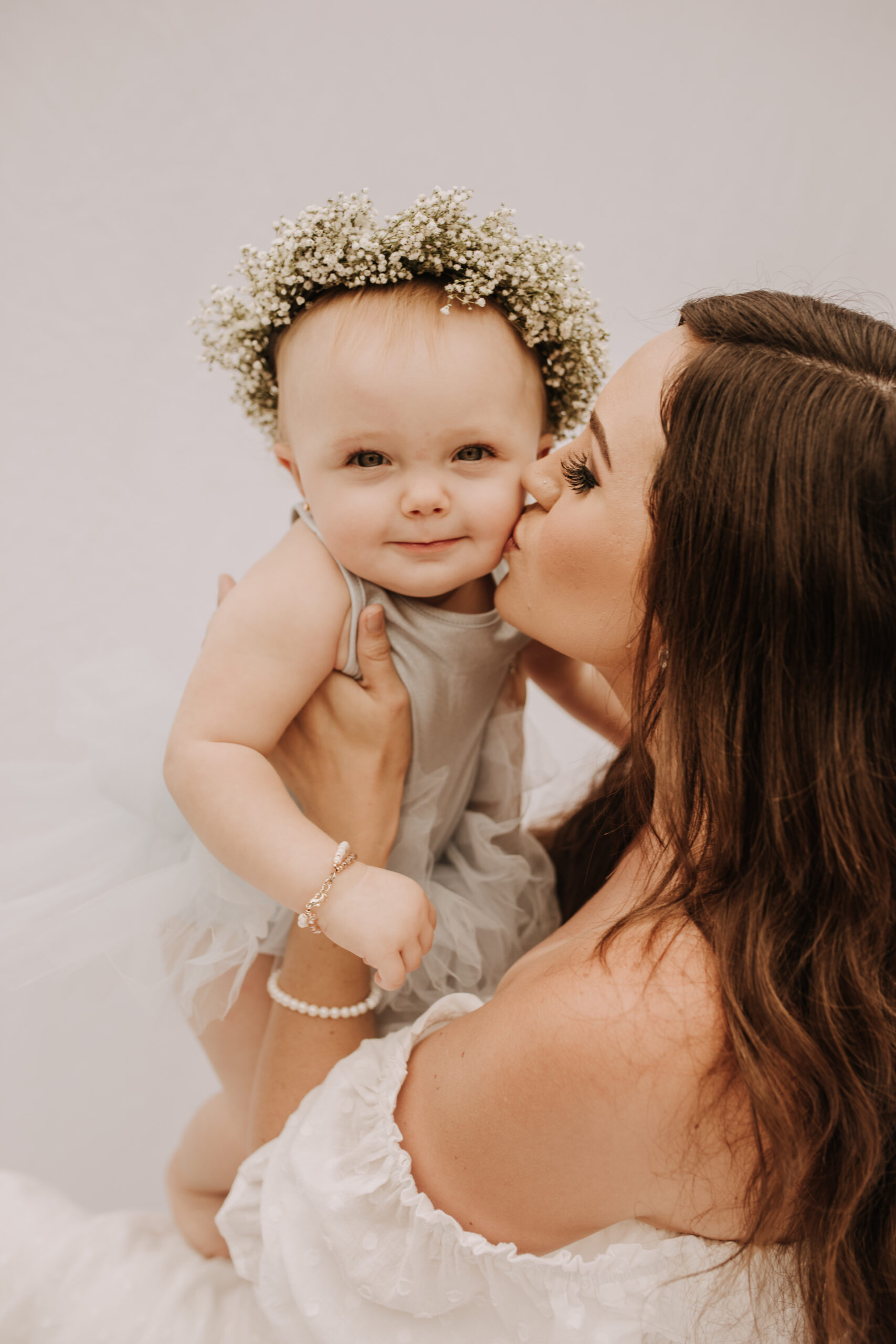 springtime soft light daisies mama and me mom and baby white dress white backdrop flower crown motherhood photos motherhood photography San Diego maternity photographer family photographer Sabrina kinsella outdoor photos green trees backyard mini session