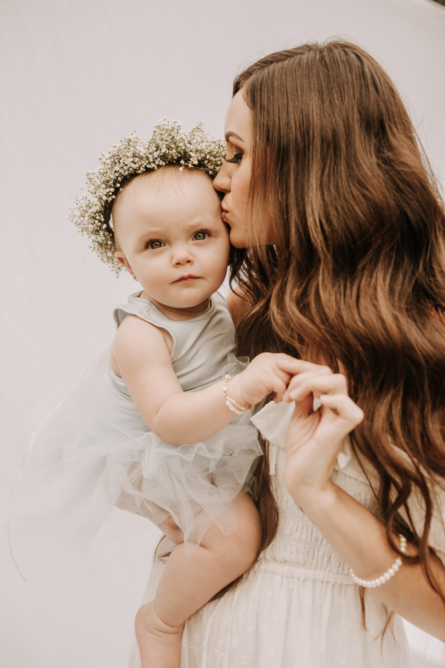 springtime soft light daisies mama and me mom and baby white dress white backdrop flower crown motherhood photos motherhood photography San Diego maternity photographer family photographer Sabrina kinsella outdoor photos green trees backyard mini session