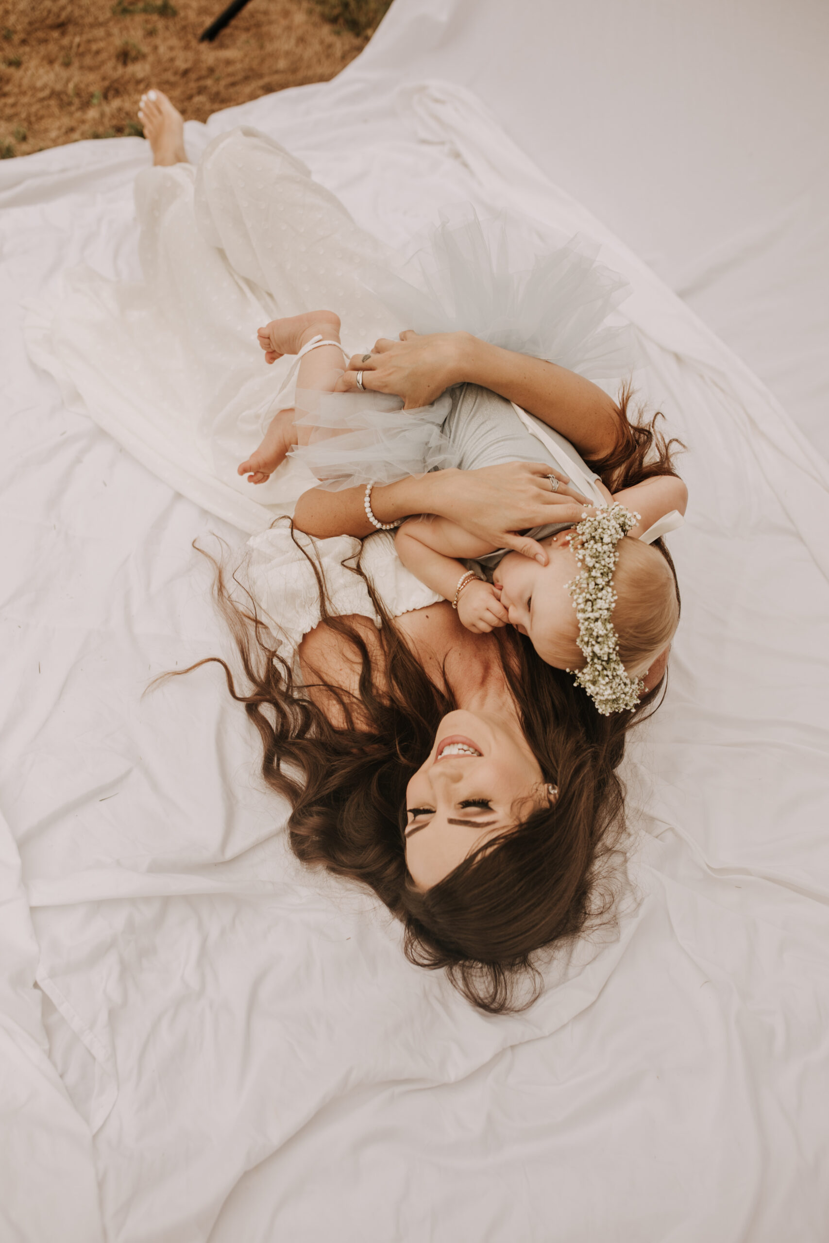 springtime soft light daisies mama and me mom and baby white dress white backdrop flower crown motherhood photos motherhood photography San Diego maternity photographer family photographer Sabrina kinsella outdoor photos green trees backyard mini session