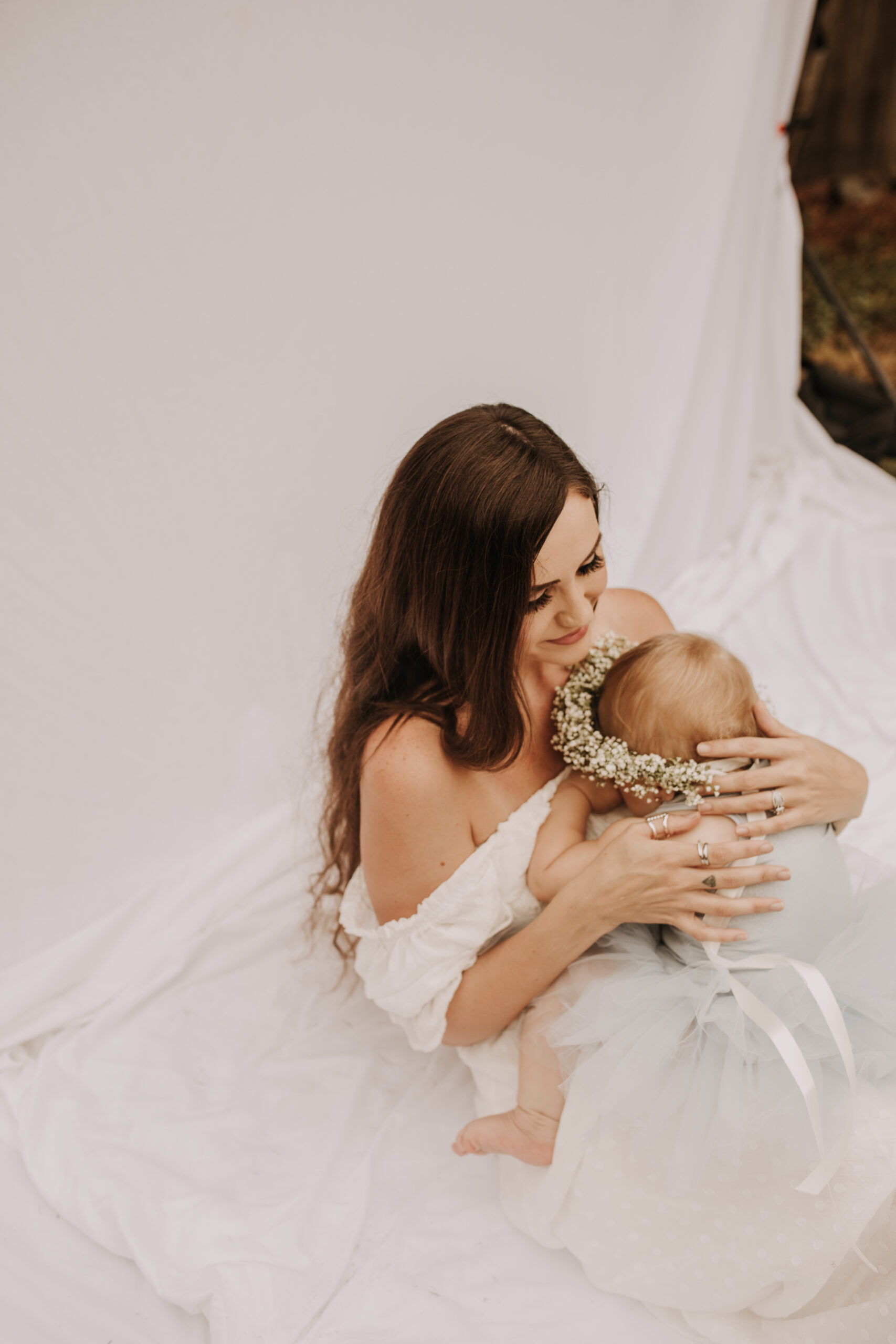 springtime soft light daisies mama and me mom and baby white dress white backdrop flower crown motherhood photos motherhood photography San Diego maternity photographer family photographer Sabrina kinsella outdoor photos green trees backyard mini session