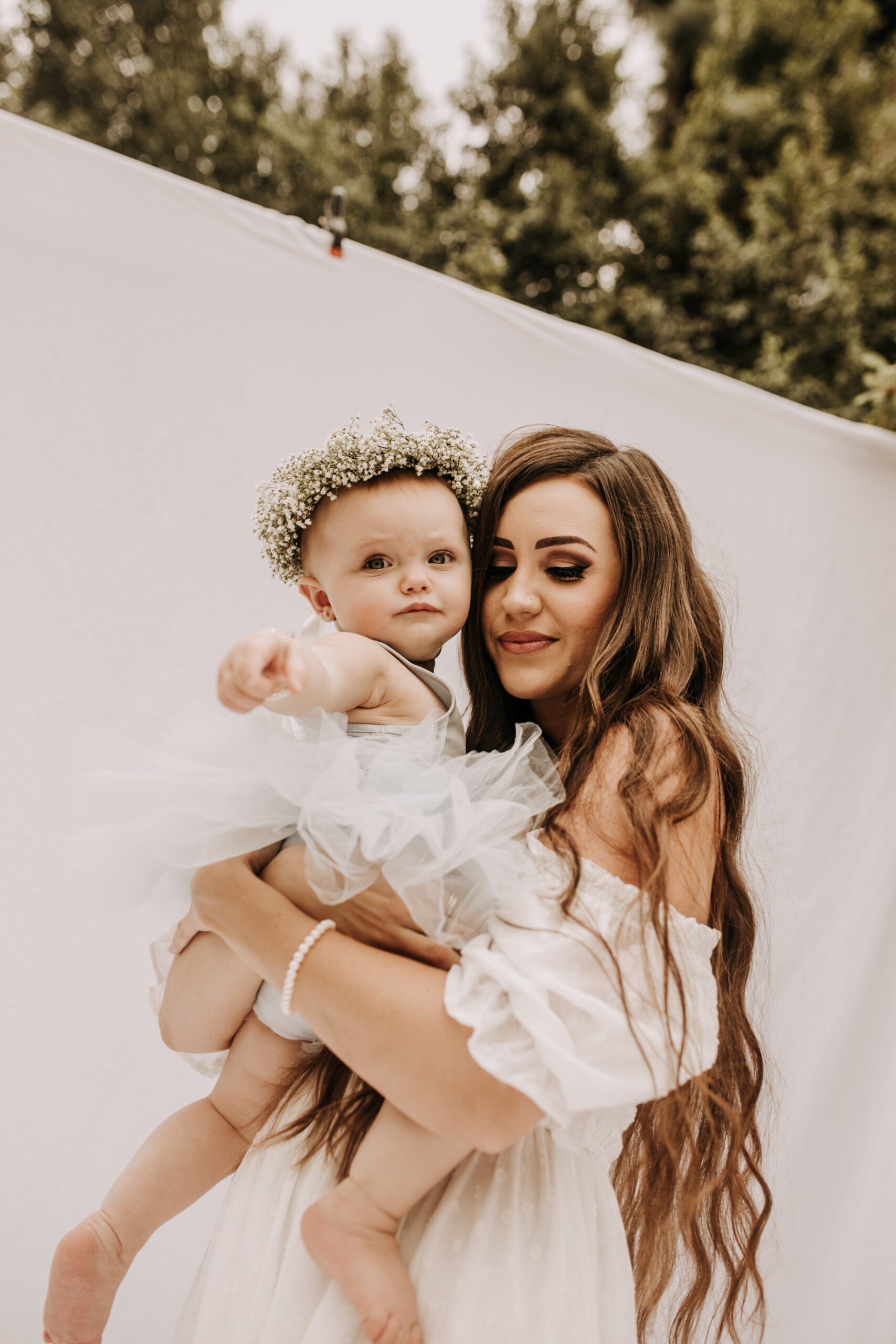 springtime soft light daisies mama and me mom and baby white dress white backdrop flower crown motherhood photos motherhood photography San Diego maternity photographer family photographer Sabrina kinsella outdoor photos green trees backyard mini session