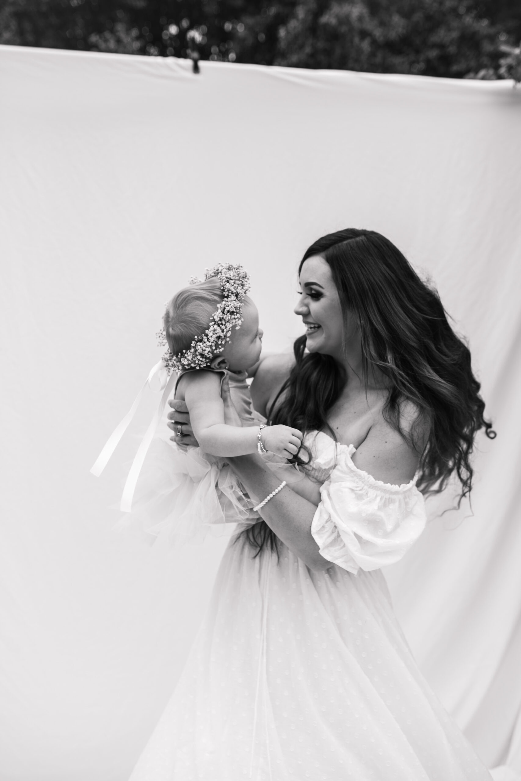 springtime soft light daisies mama and me mom and baby white dress white backdrop flower crown motherhood photos motherhood photography San Diego maternity photographer family photographer Sabrina kinsella outdoor photos green trees backyard mini session