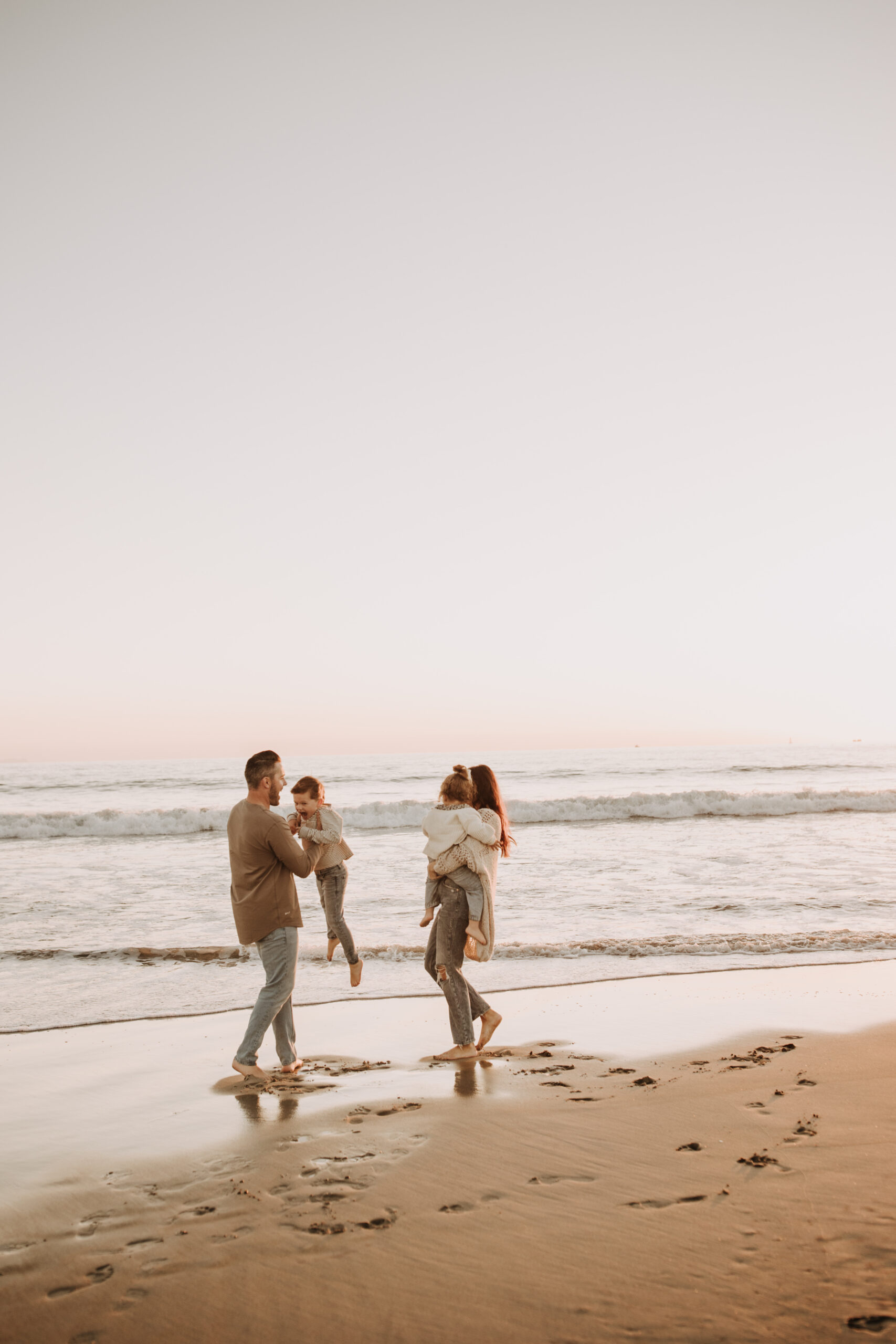 warm neutral sunset beach photos family photos on the beach golden hour family of four candid family photos love San Diego family photographer Sabrina kinsella