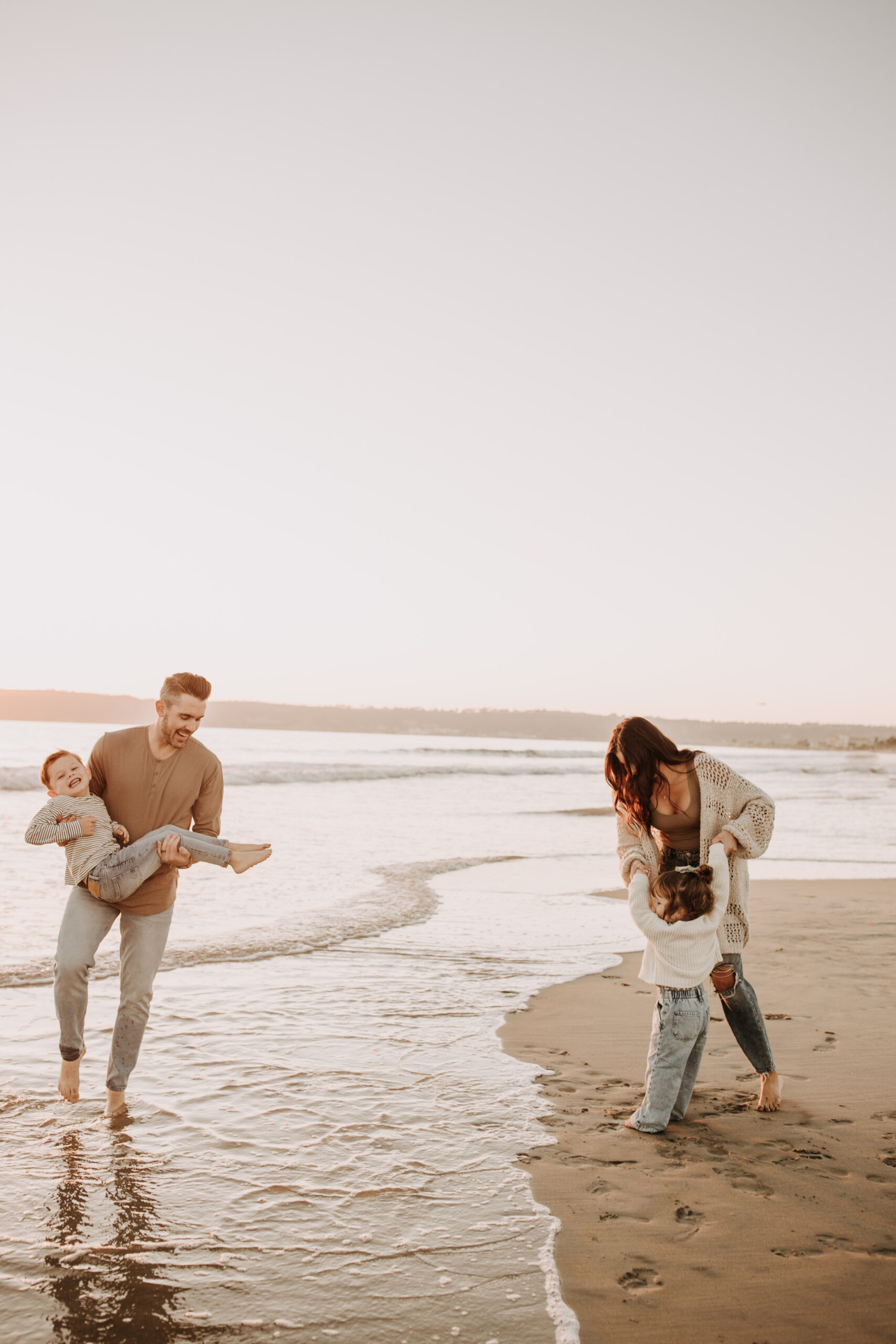 warm neutral sunset beach photos family photos on the beach golden hour family of four candid family photos love San Diego family photographer Sabrina kinsella