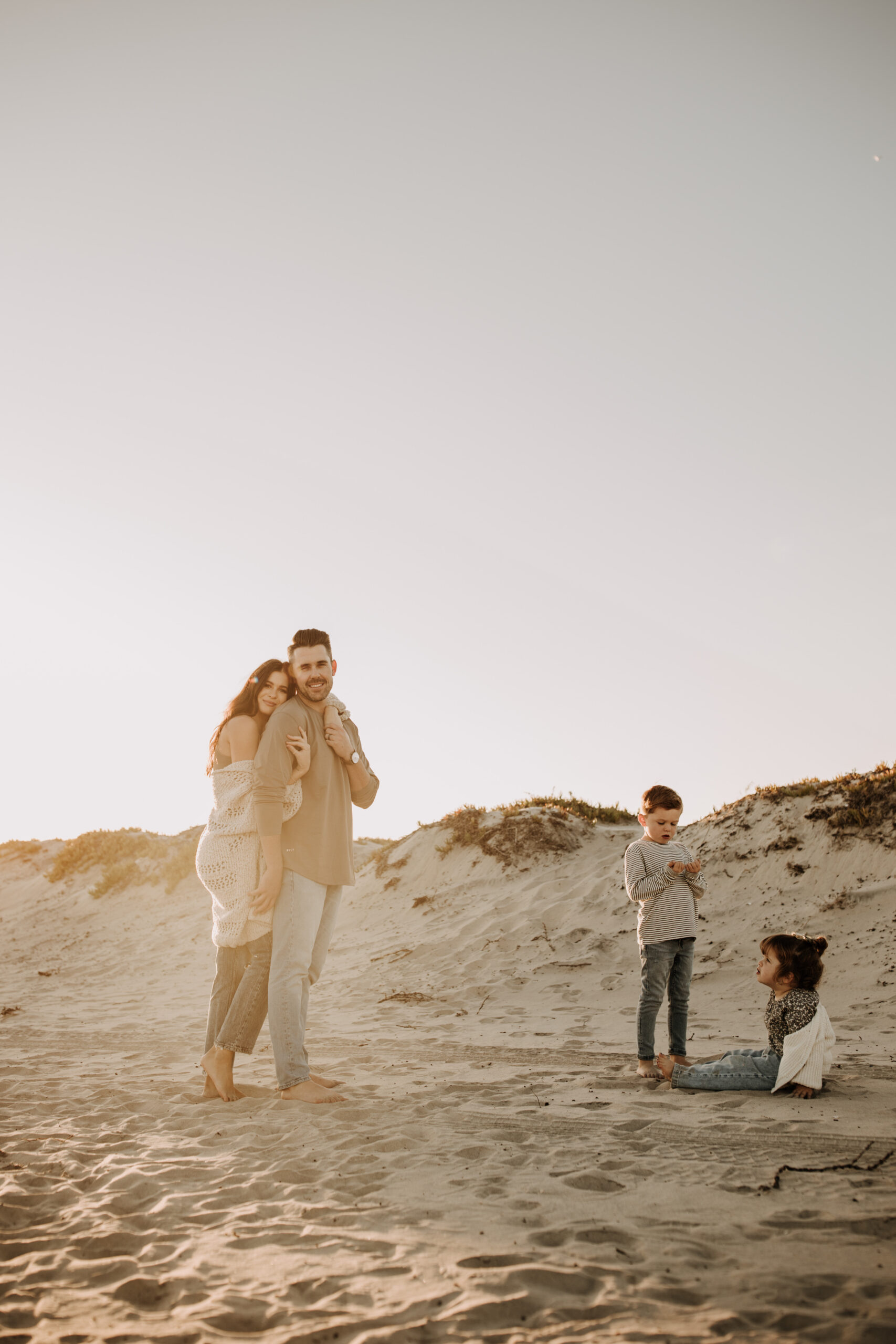 warm neutral sunset beach photos family photos on the beach golden hour family of four candid family photos love San Diego family photographer Sabrina kinsella