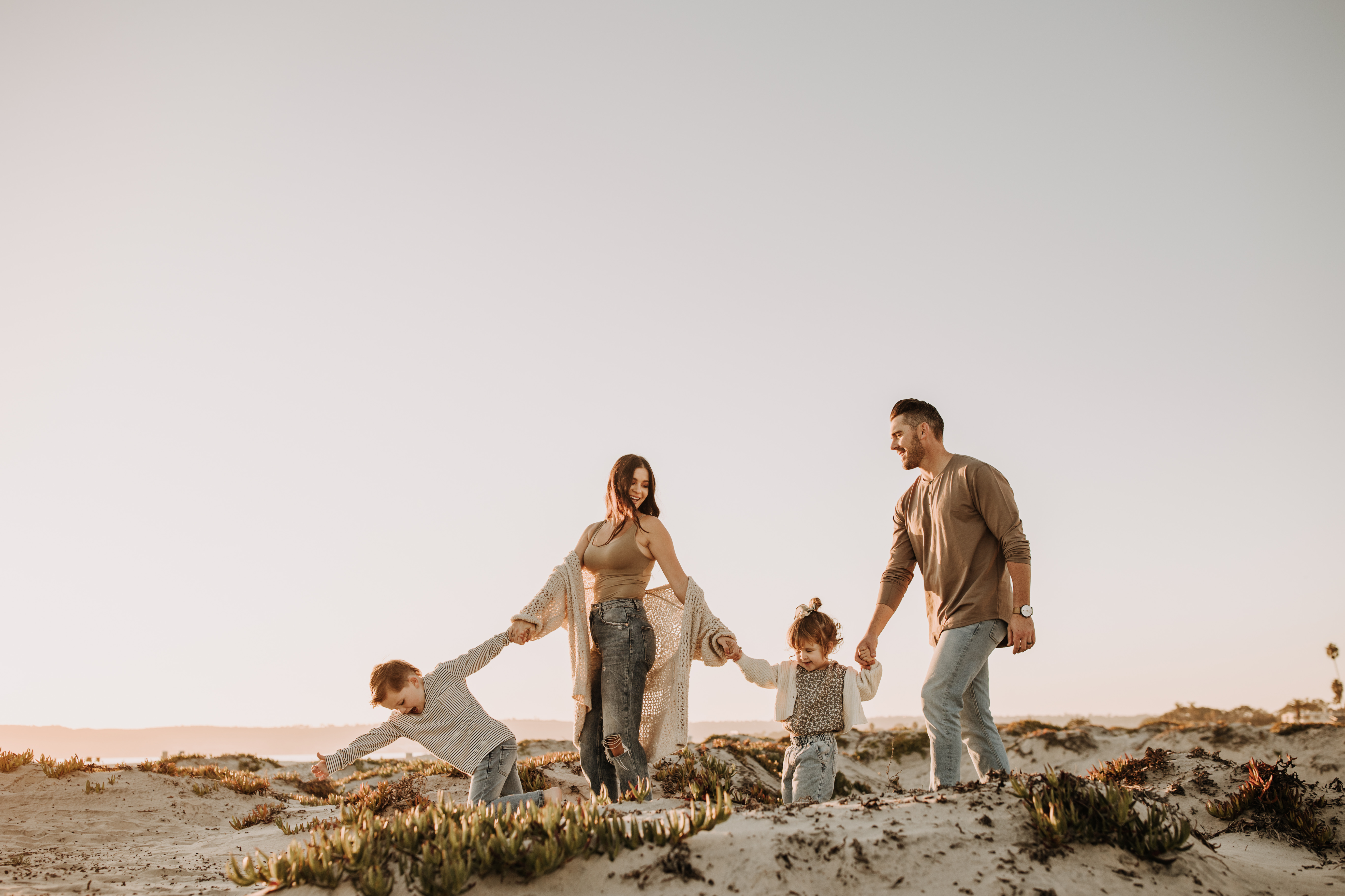 warm neutral sunset beach photos family photos on the beach golden hour family of four candid family photos love San Diego family photographer Sabrina kinsella 