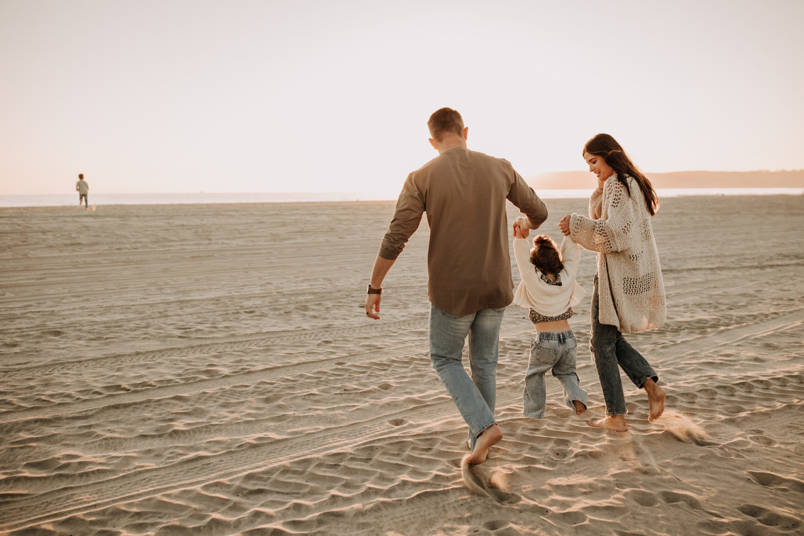 warm neutral sunset beach photos family photos on the beach golden hour family of four candid family photos love San Diego family photographer Sabrina kinsella