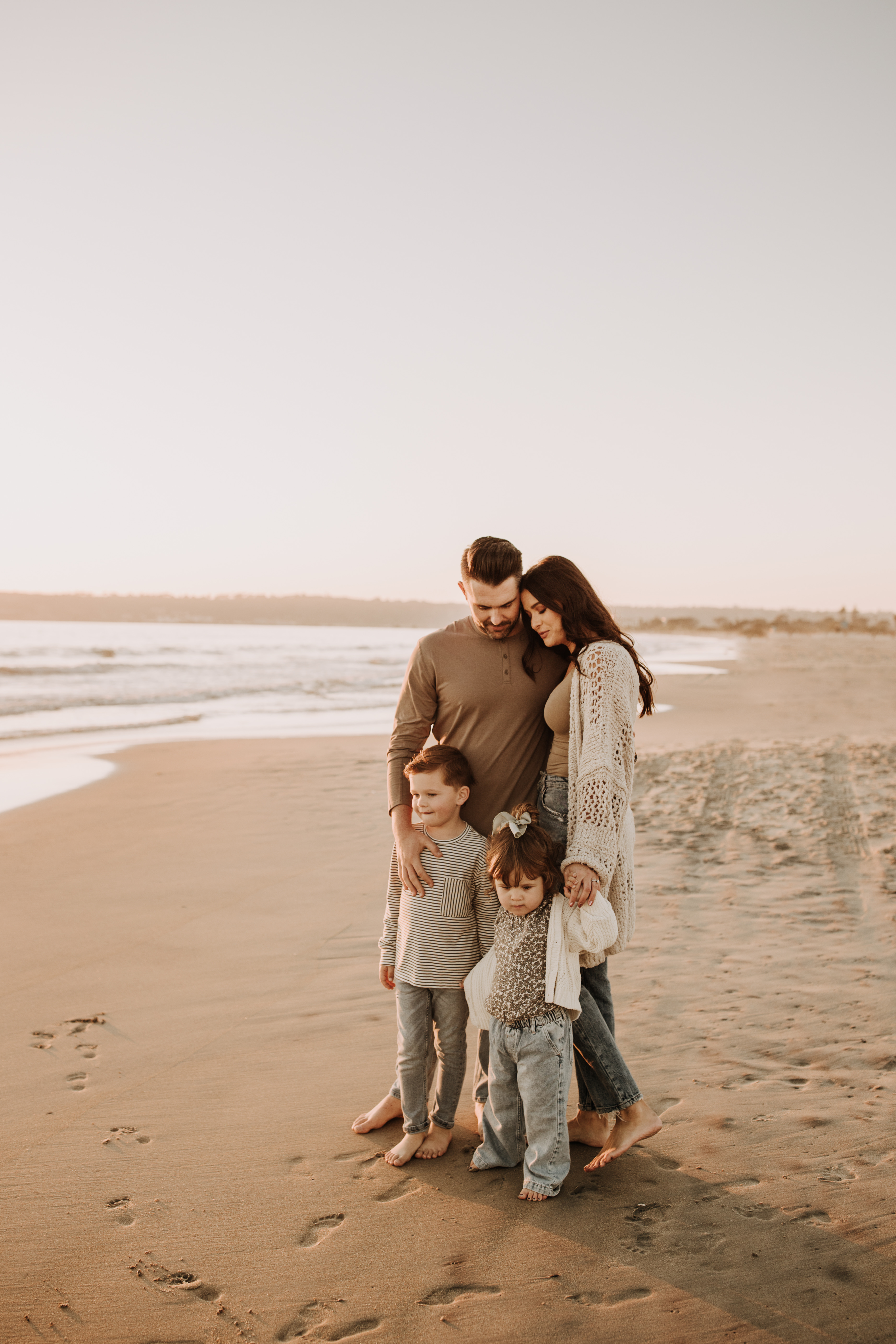 warm neutral sunset beach photos family photos on the beach golden hour family of four candid family photos love San Diego family photographer Sabrina kinsella 