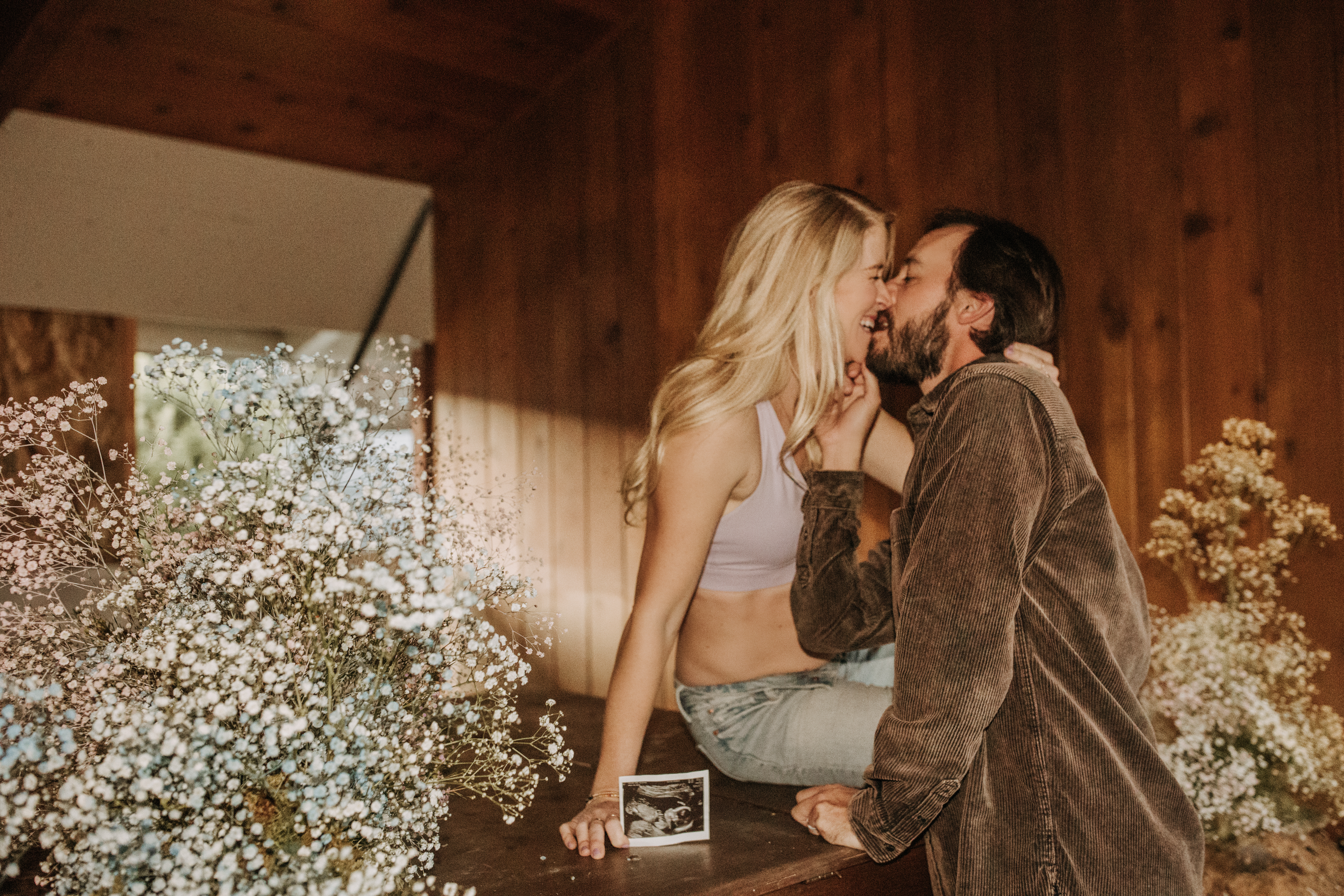 in home San Diego maternity photos raw real family photos gender reveal photos with flowers babies breath pink and blue boy or girl reveal ultrasound pregnancy photos San Diego maternity photographer Sabrina kinsella sabrinalynn photo