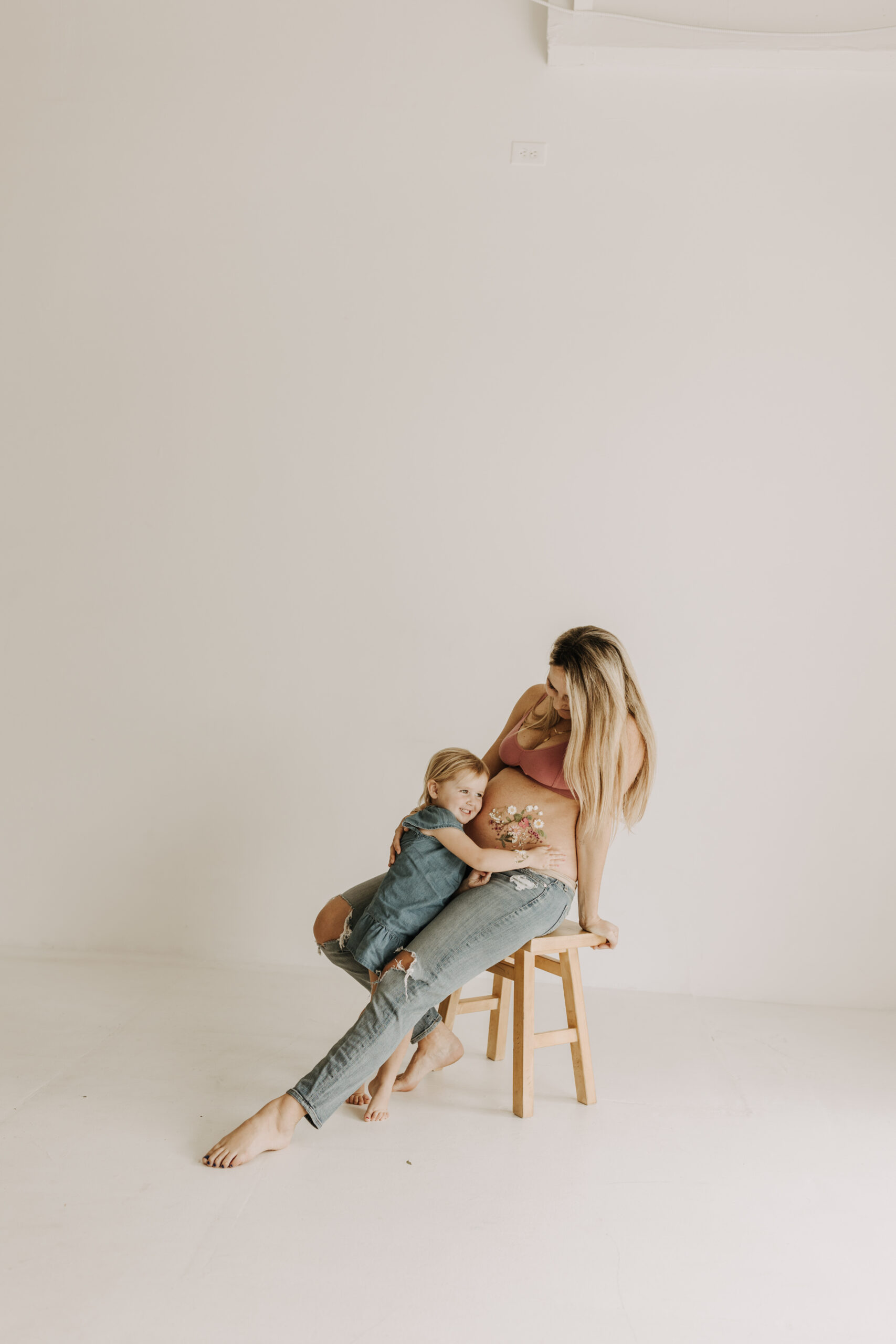 studio photography session pink maternity photos in a studio white backdrop pink confetti streamers mama and me motherhood mini sessions family photos candid maternity photos styled shoot San Diego maternity photographer Sabrinalynnphoto Sabrina kinsella