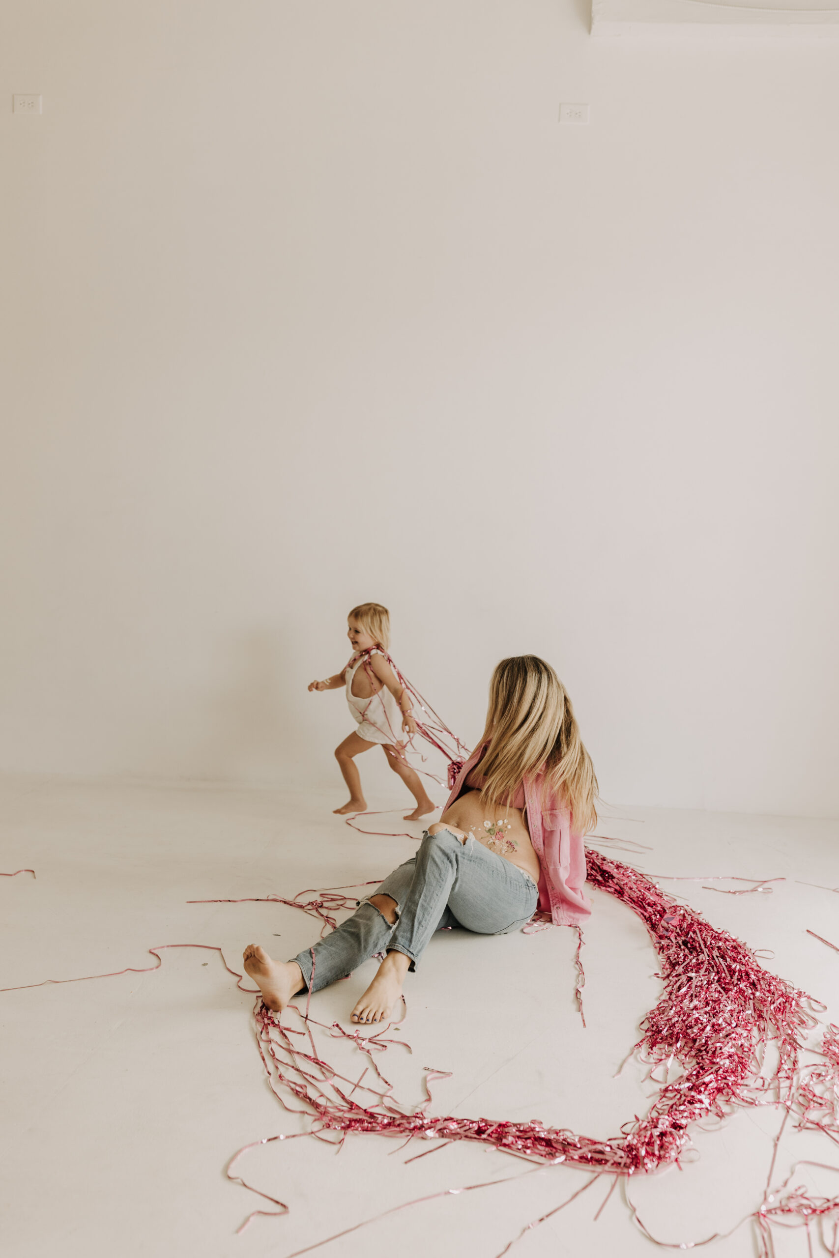 studio photography session pink maternity photos in a studio white backdrop pink confetti streamers mama and me motherhood mini sessions family photos candid maternity photos styled shoot San Diego maternity photographer Sabrinalynnphoto Sabrina kinsella