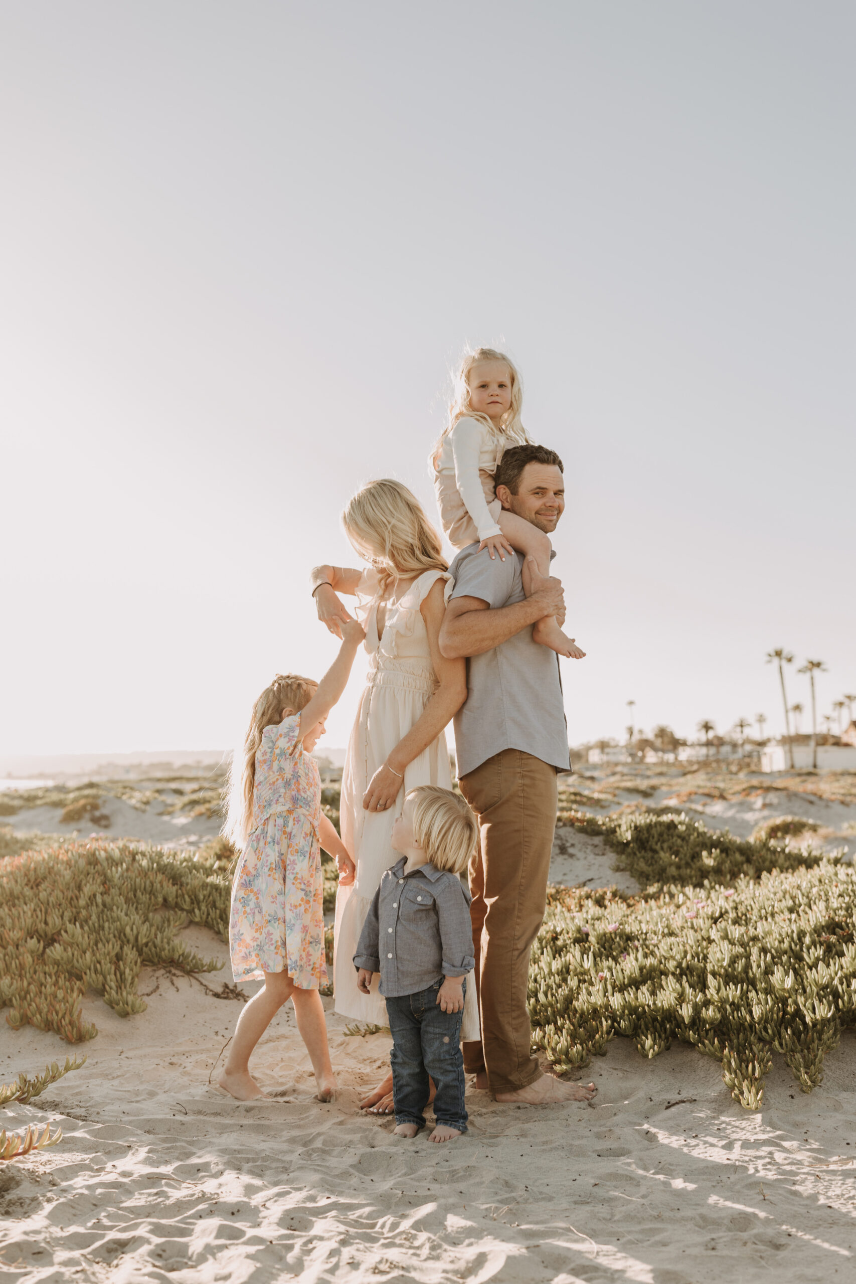 beach family photos sunset golden hour candid family photos family of four at sunset on the beach san Diego family photographer Sabrina kinsella sabrinalynnphoto