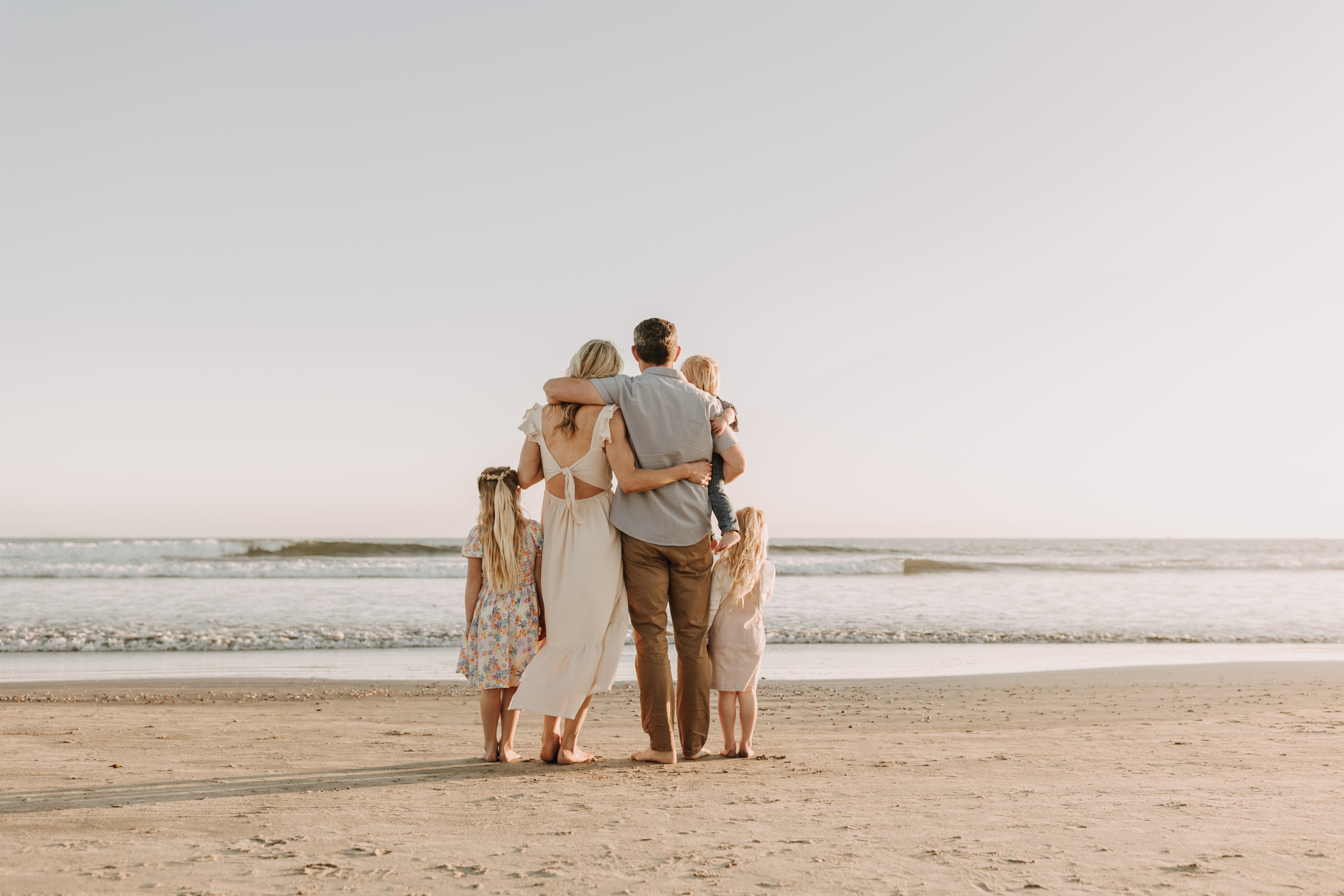 beach family photos sunset golden hour candid family photos family of four at sunset on the beach san Diego family photographer Sabrina kinsella sabrinalynnphoto