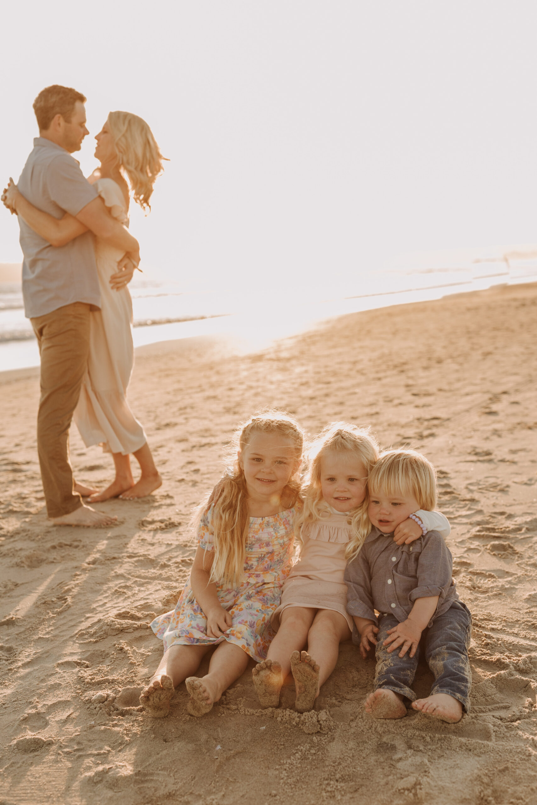 beach family photos sunset golden hour candid family photos family of four at sunset on the beach san Diego family photographer Sabrina kinsella sabrinalynnphoto