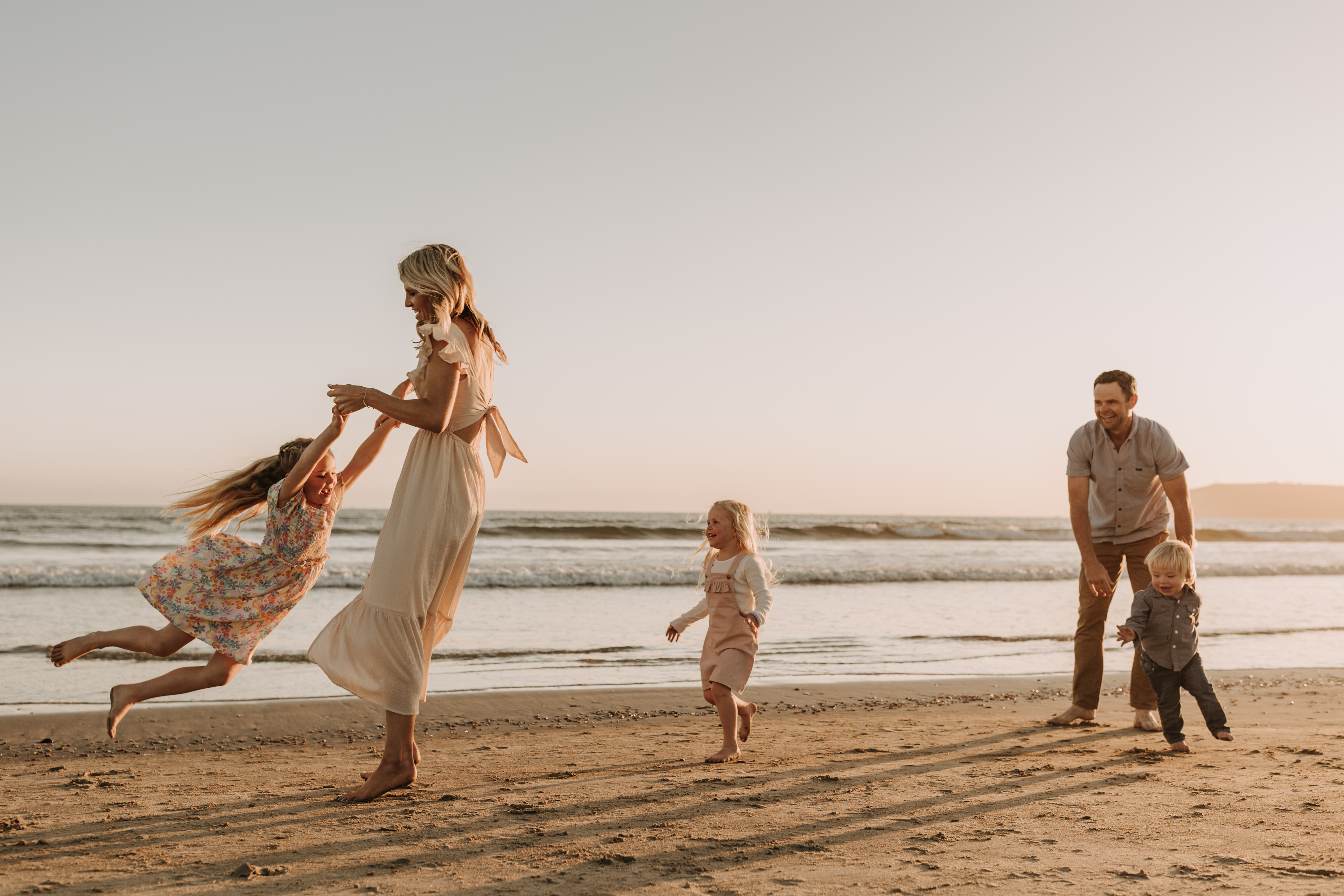 beach family photos sunset golden hour candid family photos family of four at sunset on the beach san Diego family photographer Sabrina kinsella sabrinalynnphoto