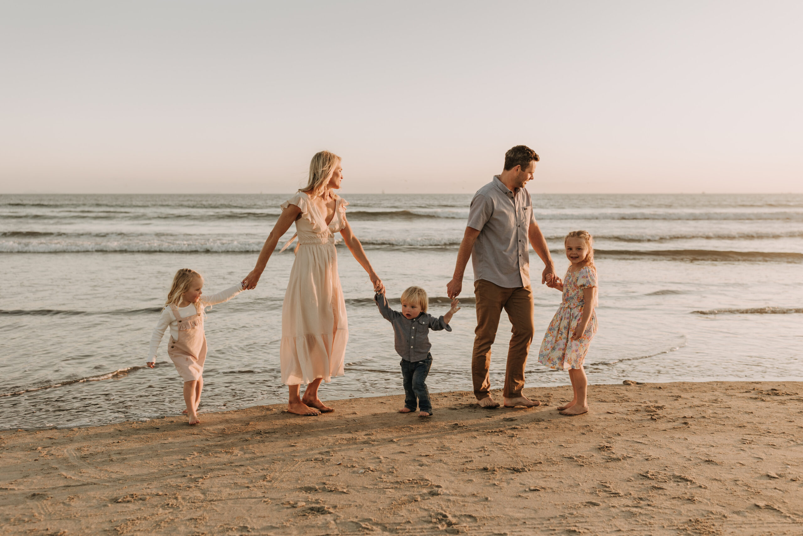 beach family photos sunset golden hour candid family photos family of four at sunset on the beach san Diego family photographer Sabrina kinsella sabrinalynnphoto