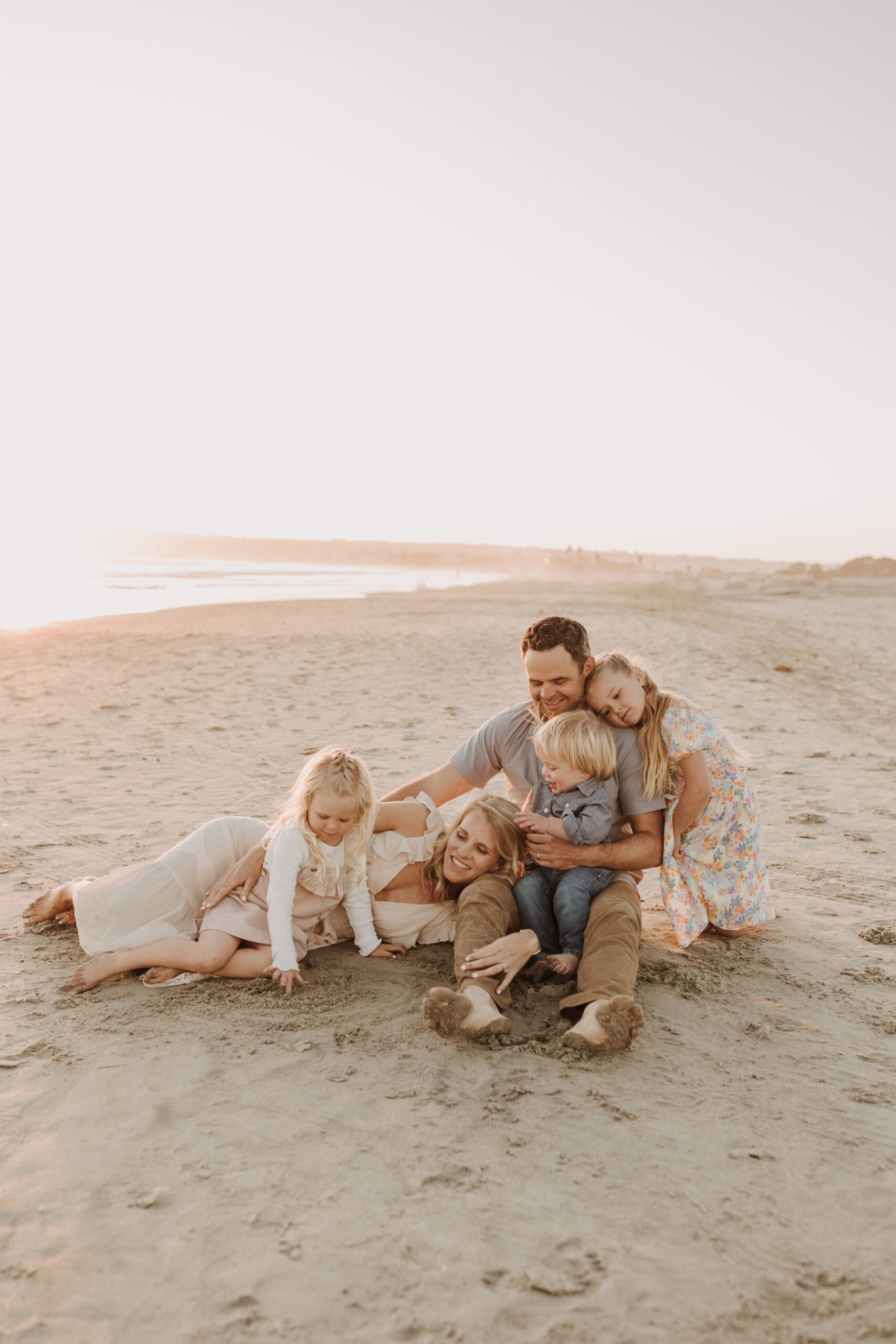 beach family photos sunset golden hour candid family photos family of four at sunset on the beach san Diego family photographer Sabrina kinsella sabrinalynnphoto