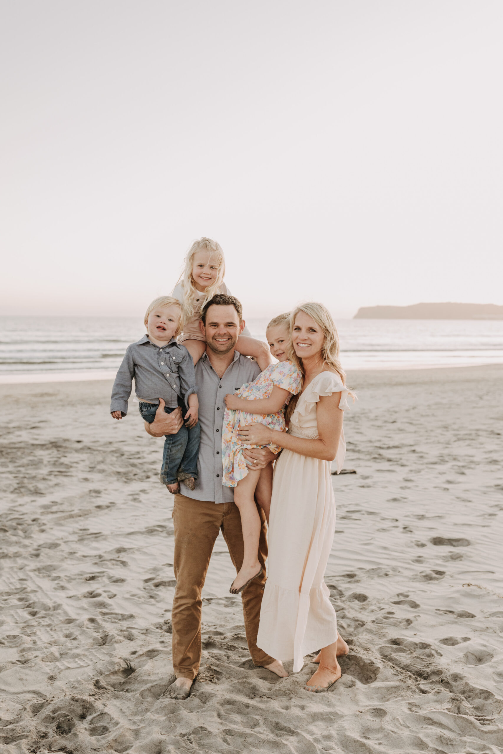 beach family photos sunset golden hour candid family photos family of four at sunset on the beach san Diego family photographer Sabrina kinsella sabrinalynnphoto